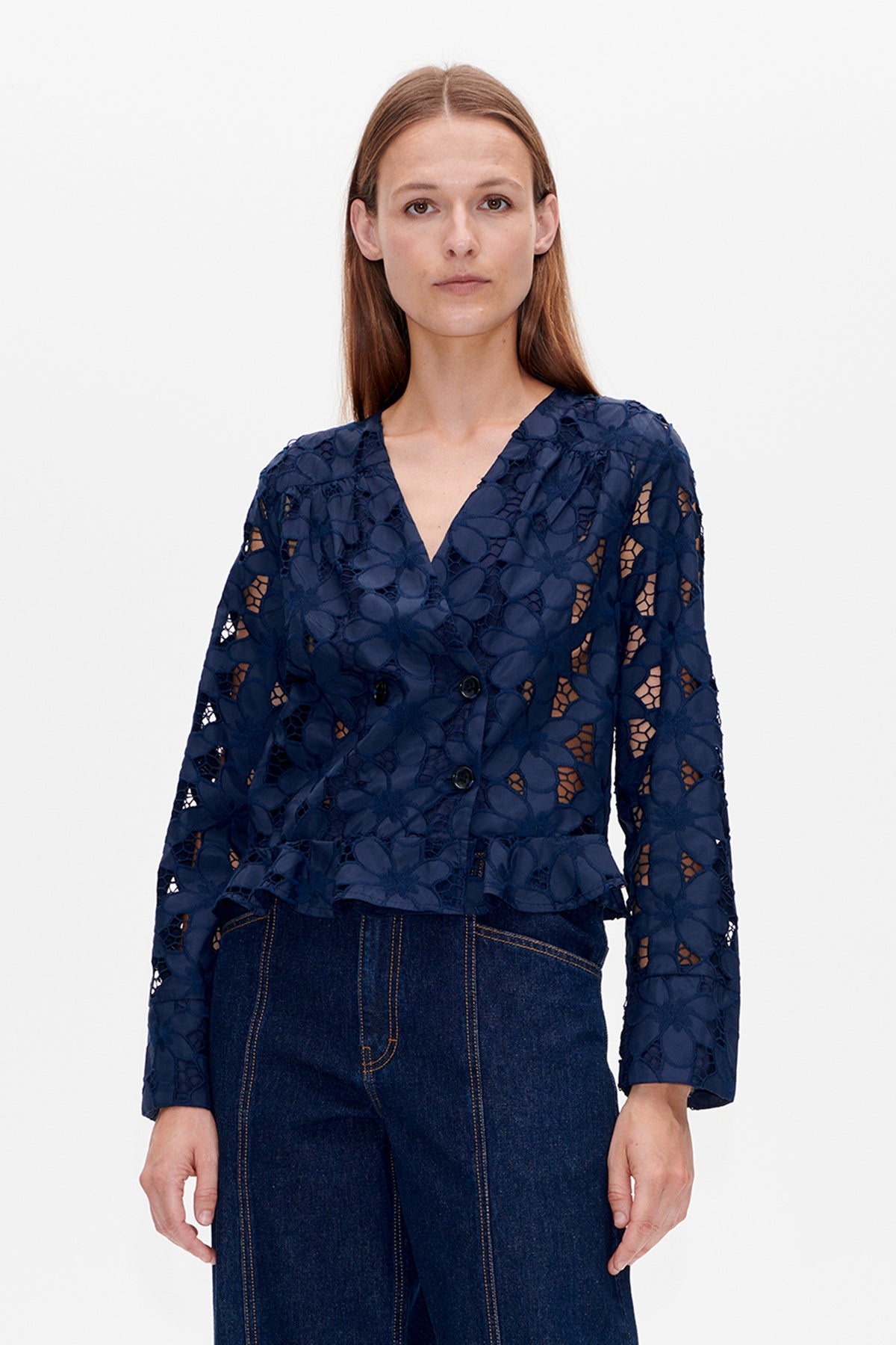 Front view of a navy blouse with a V-neck, button front, elbow-length sleeves and a raised floral pattern with openwork details.