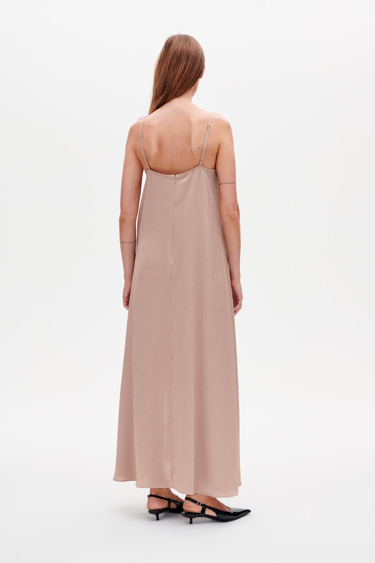 Back view of a long dusty rose slip dress with thin straps, subtle tonal texture, and a center-back zip.