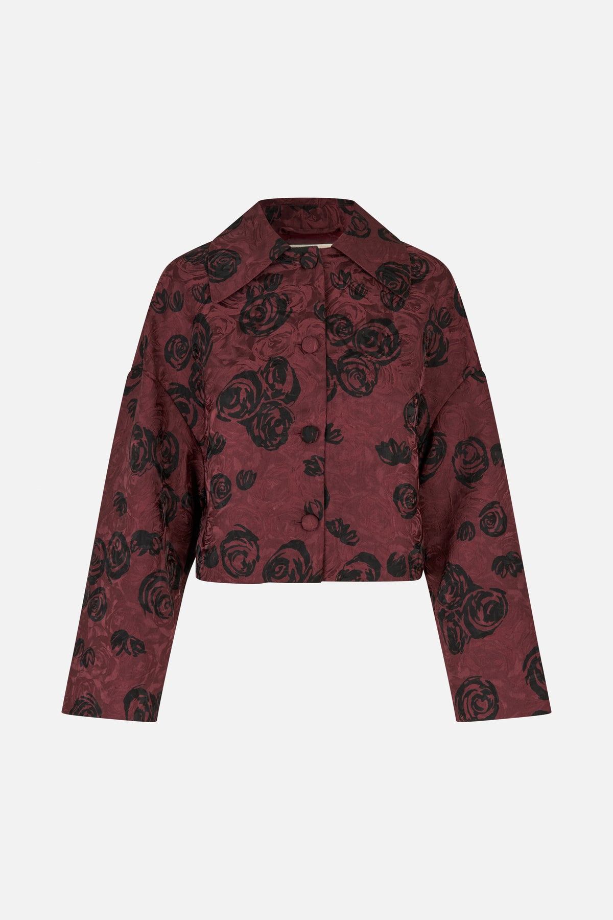 Vooraanzicht van een kort bordeauxrood jasje met zwarte rozenprint, een brede kraag, lange mouwen en bedekte knopen.