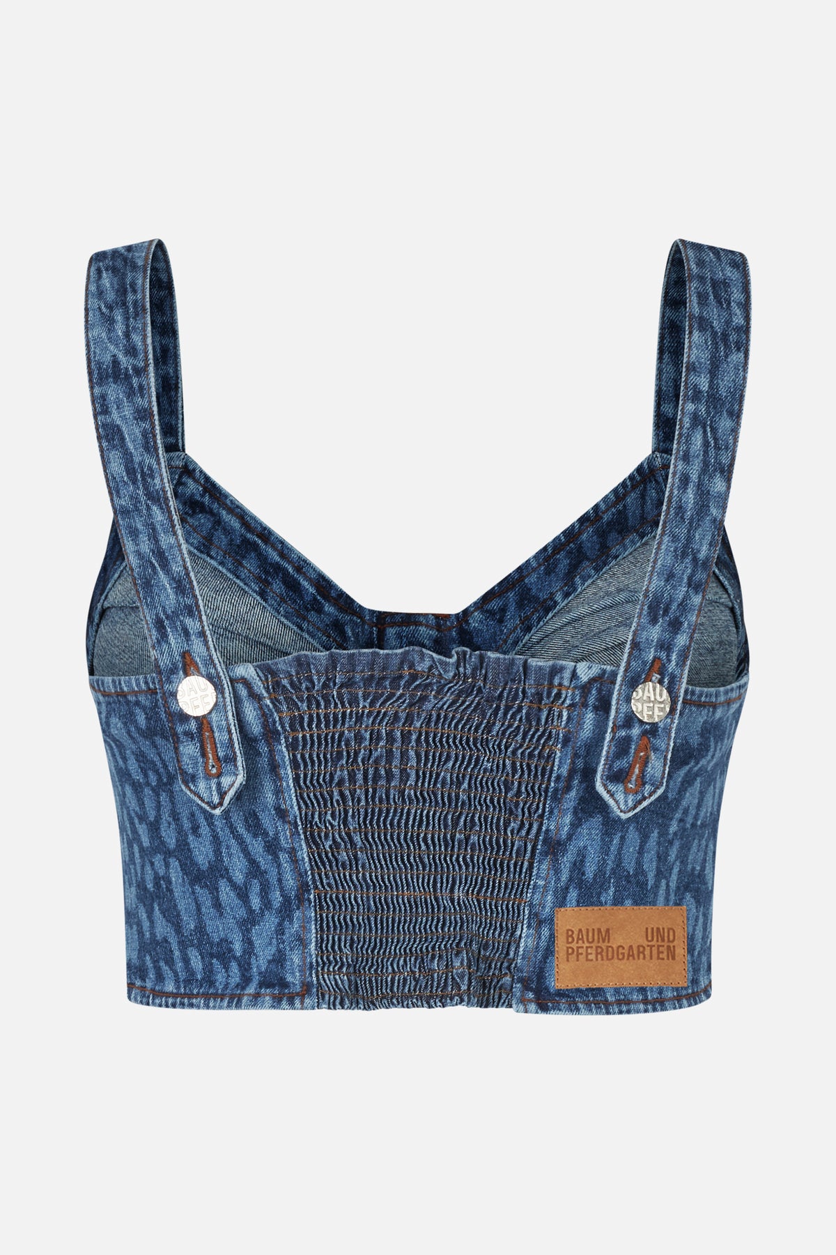 Close-up of a blue washed-denim top with wide straps, button tabs and a ruched elasticated front panel.