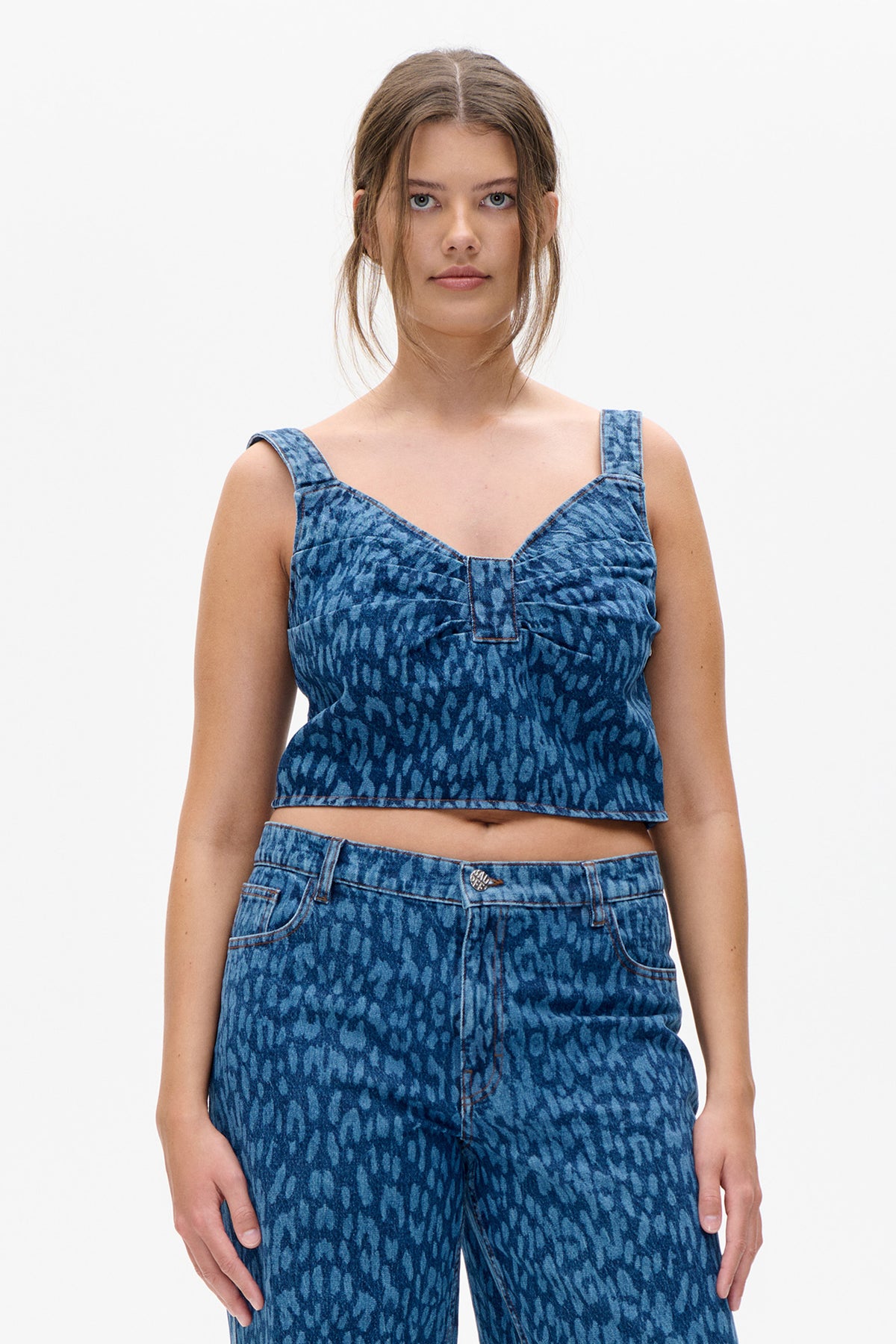 Front view of a blue patterned sleeveless crop top with wide straps and matching high-waisted jeans