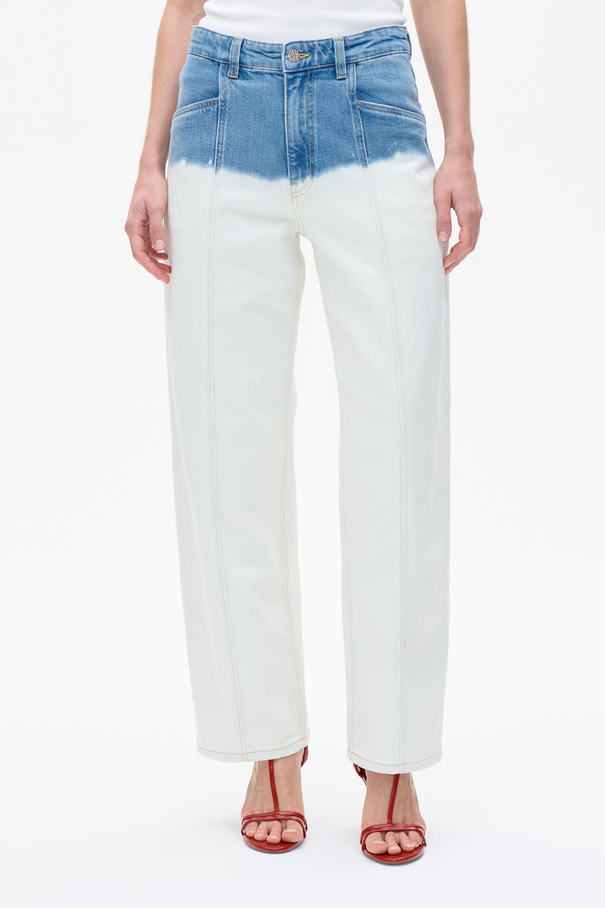 Vooraanzicht van cropped jeans met blauw denim in de taille dat uitloopt naar licht ivoorkleurige pijpen, met contrasterende stiksels en voorzakken.
