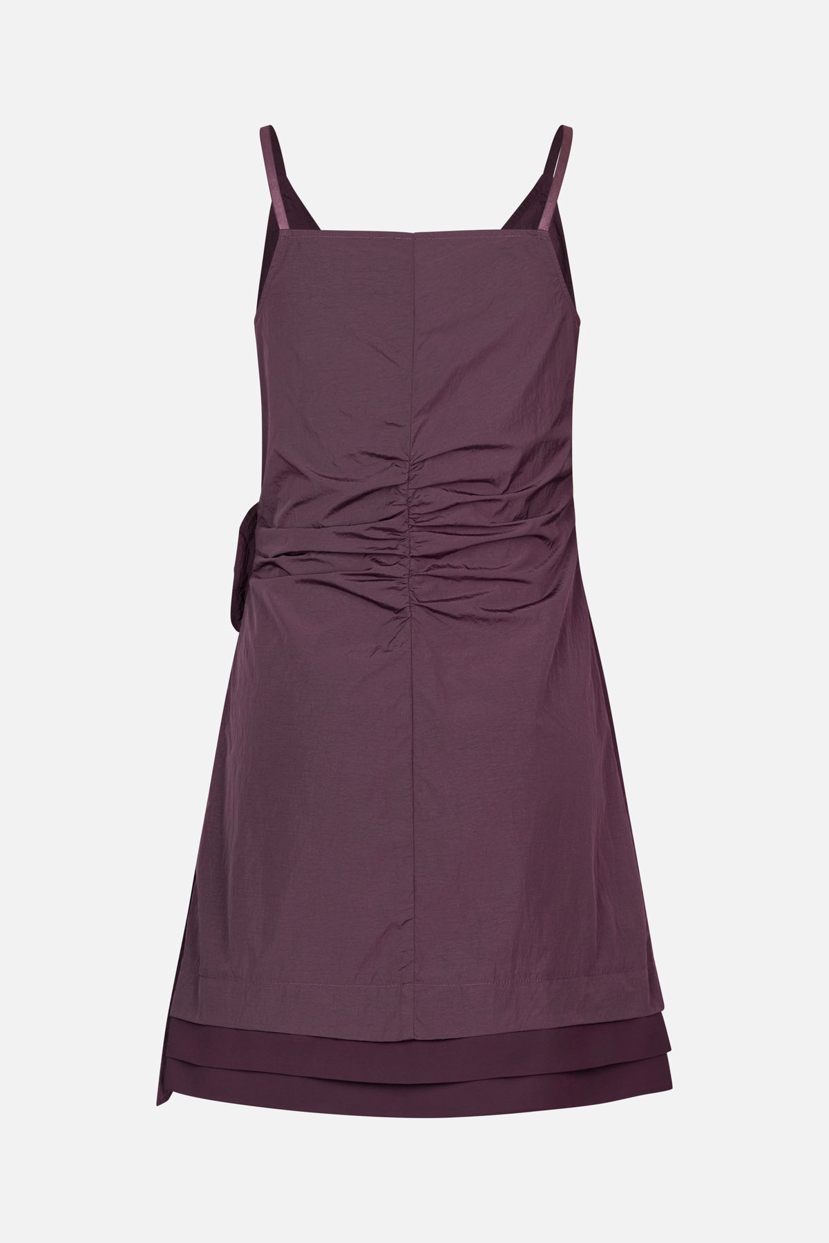 Front view of a deep plum sleeveless dress with thin straps, a square neckline, gathered ruching at the waist and a layered hem.