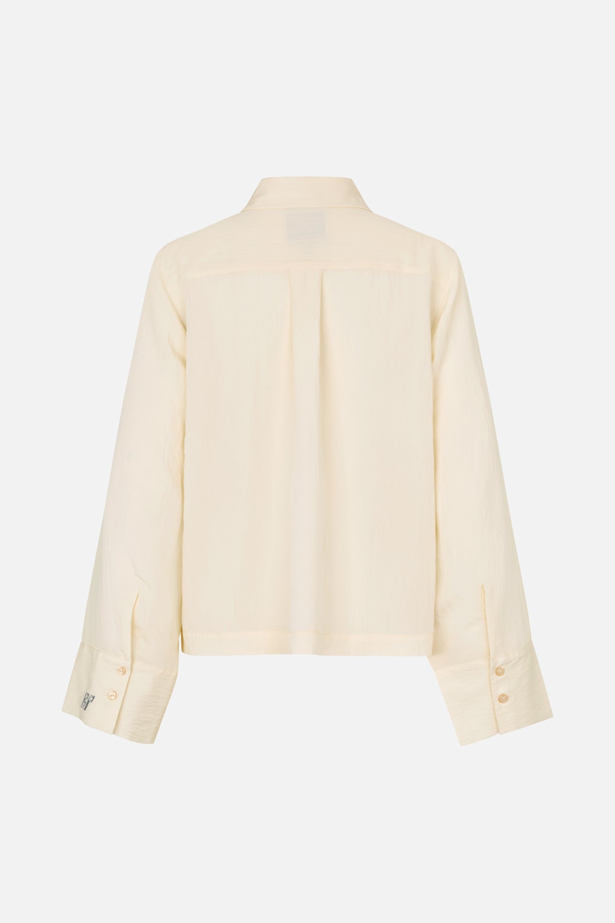 Back view of an ivory long-sleeved shirt with a pointed collar, shoulder yoke, center pleat and wide button cuffs.