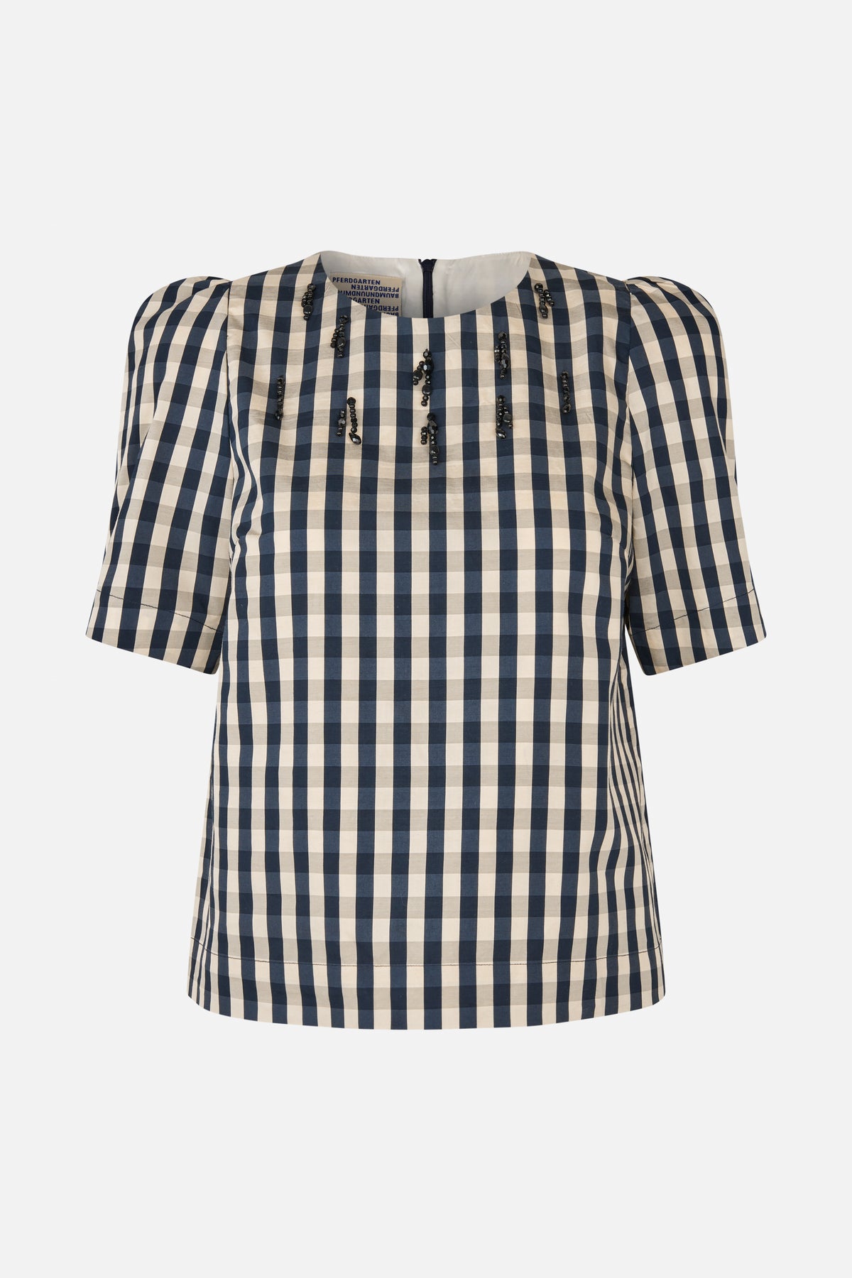 Front view of a short-sleeved top with a navy and cream checked pattern and black embellishments across the chest.
