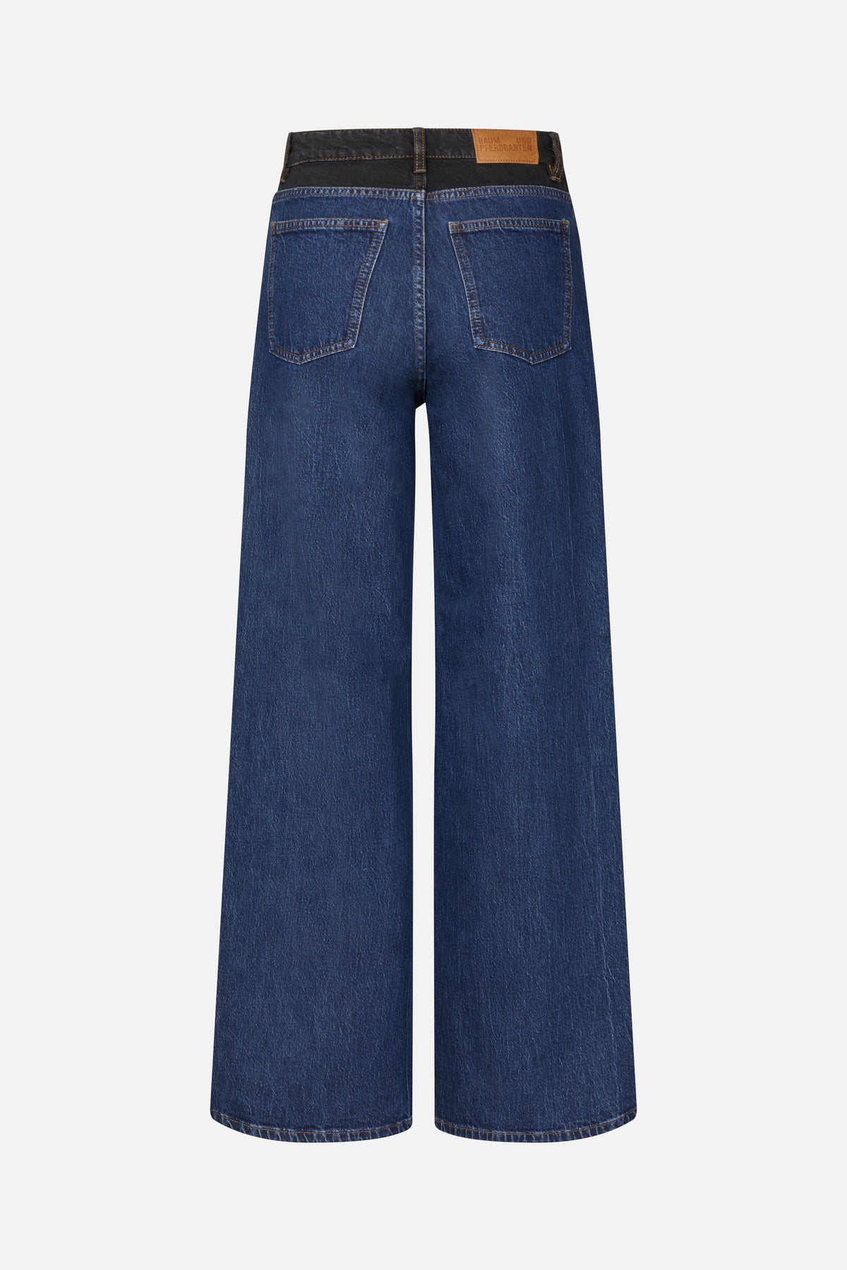 Rückansicht dunkelblauer Jeans mit weitem Bein, kontrastierendem schwarzen Bund, hellbraunen Nähten, zwei Gesäßtaschen und hellbraunem Logo-Patch.