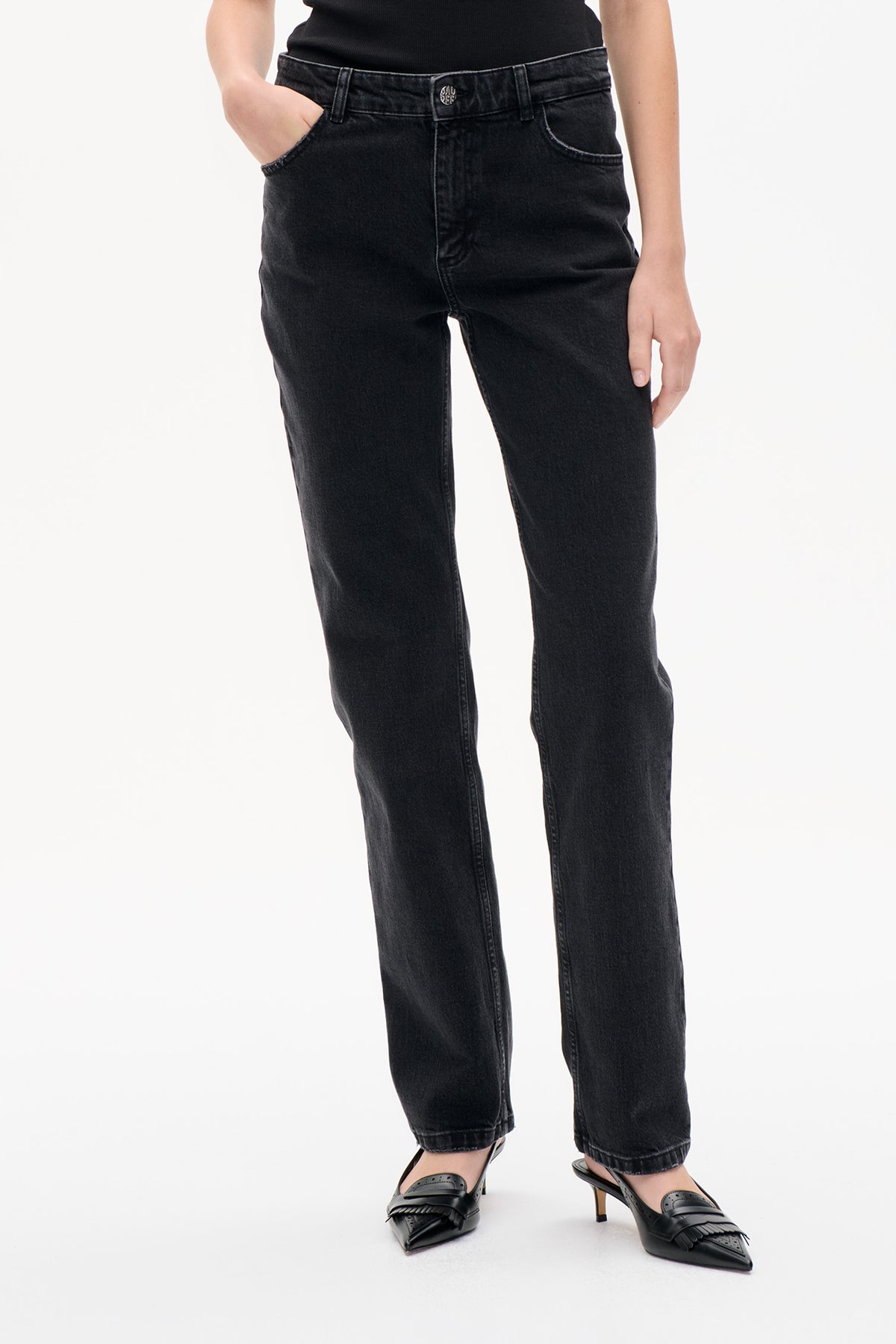 Front detail of black washed denim jeans with a button fly, belt loops, curved pockets and straight legs.