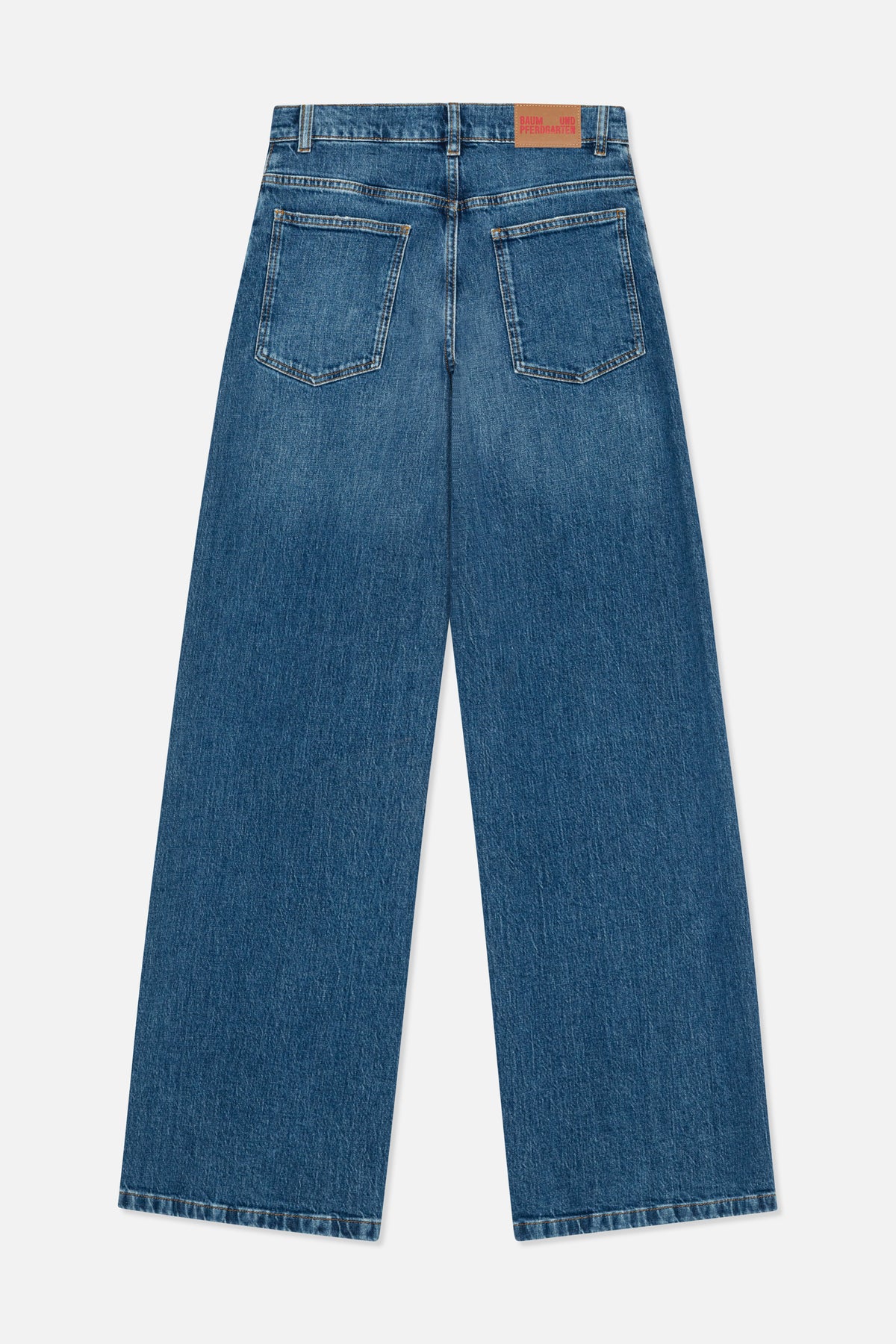 Back view of blue straight-leg jeans with two patch pockets, belt loops and a tan logo patch.