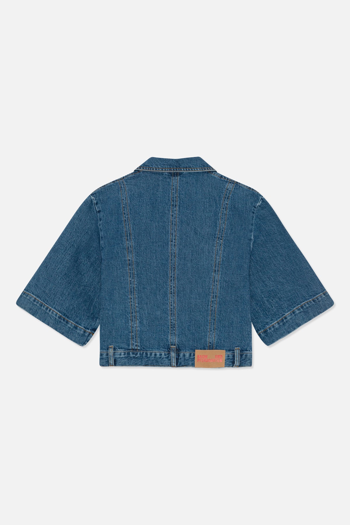 Back view of a blue denim jacket with short sleeves, contrast stitching, panel seams and a tan hem patch.