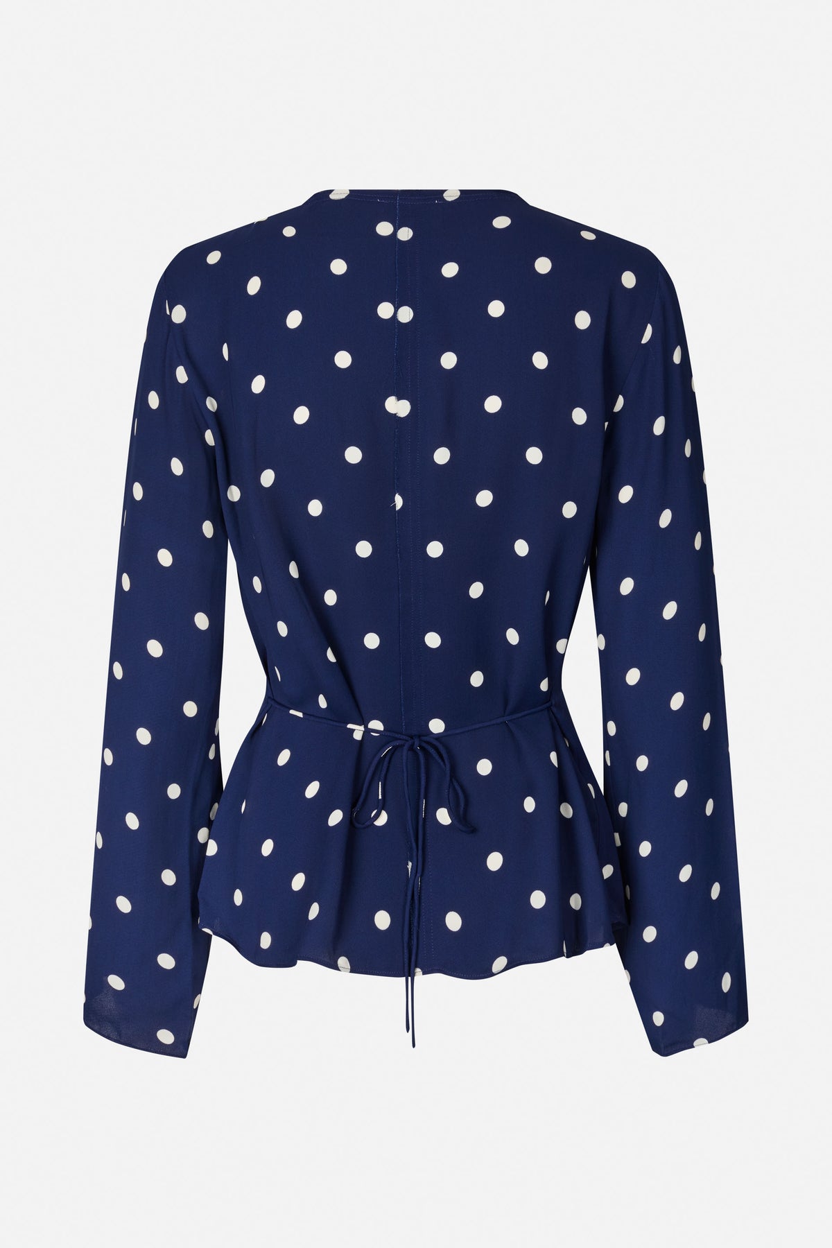 Rückansicht einer marineblauen, langärmeligen Bluse mit weißen Punkten, mittiger Naht und Taillenband.