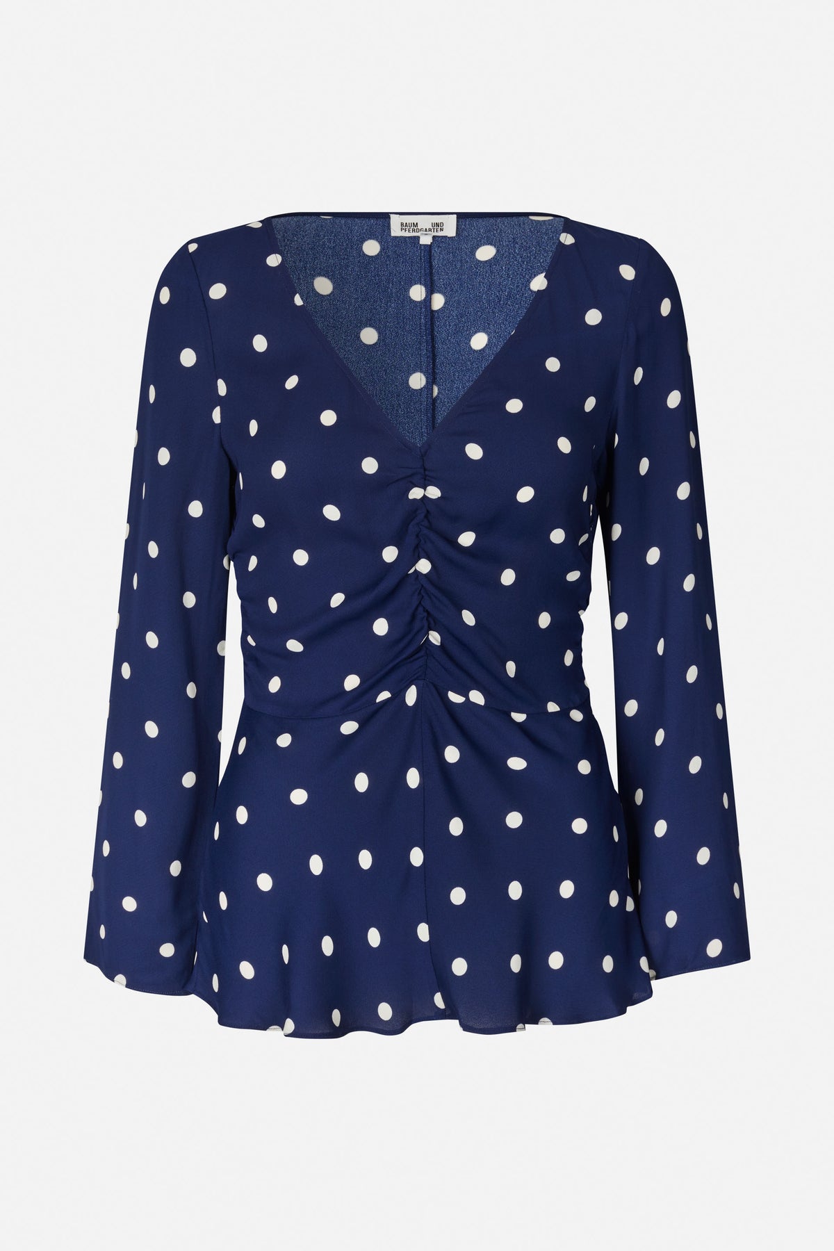 Navy long-sleeved blouse with white polka dots, a V-neckline, gathered front and flared hem