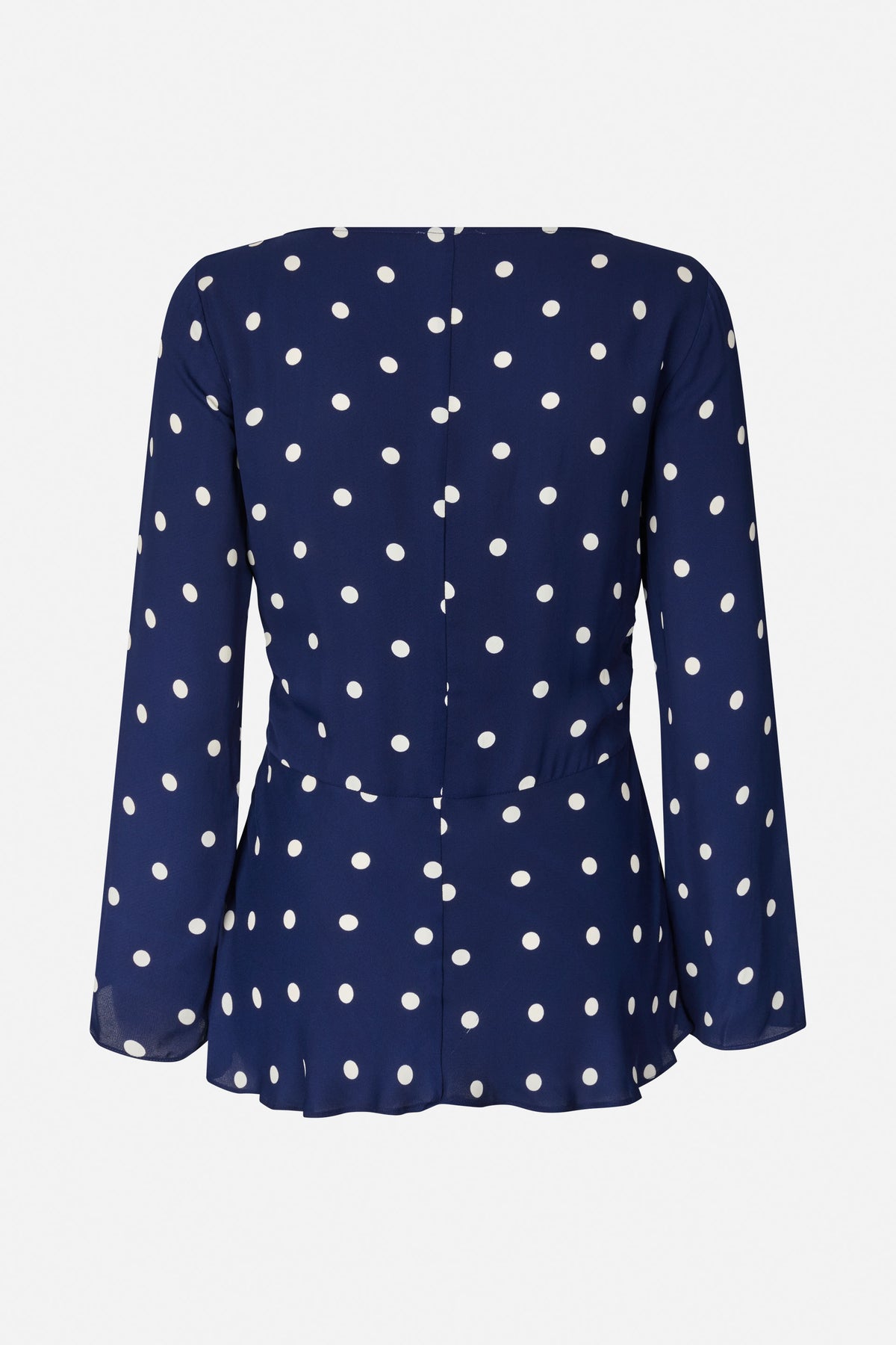 Achteraanzicht van een marineblauwe blouse met lange mouwen en witte stippen, met een centrale naad en een uitlopende peplumzoom.