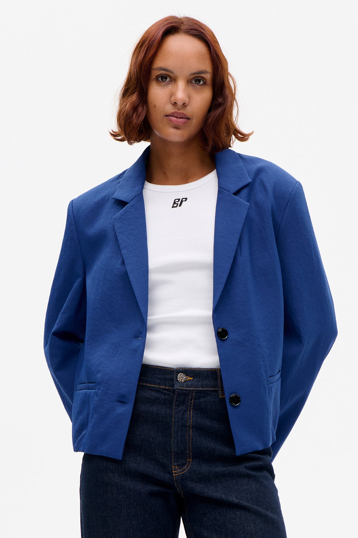 Front view of a model wearing a bright blue single-breasted blazer over a white ribbed T-shirt with a small BP logo.