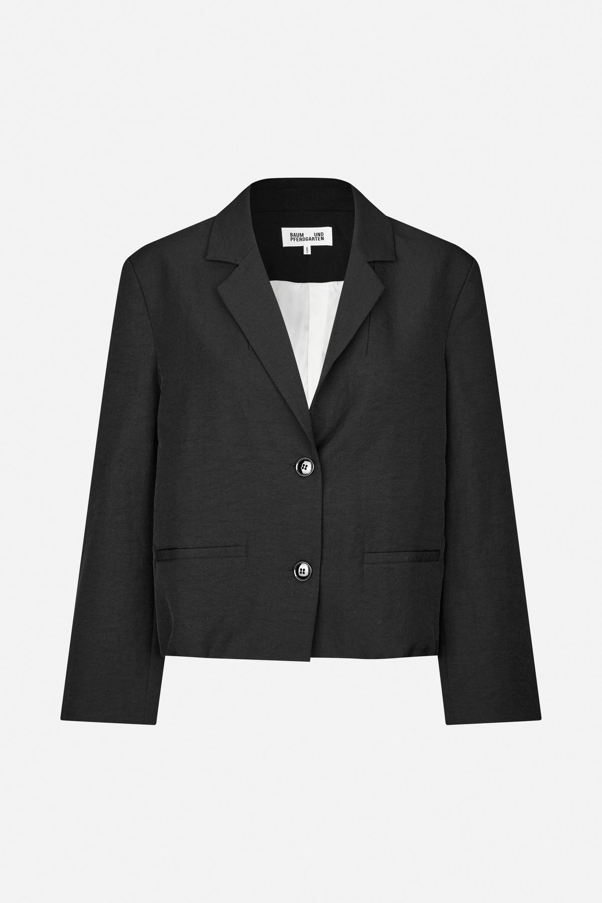 Front view of a cropped black blazer with notched lapels, two buttons, flap pockets and a white lining.