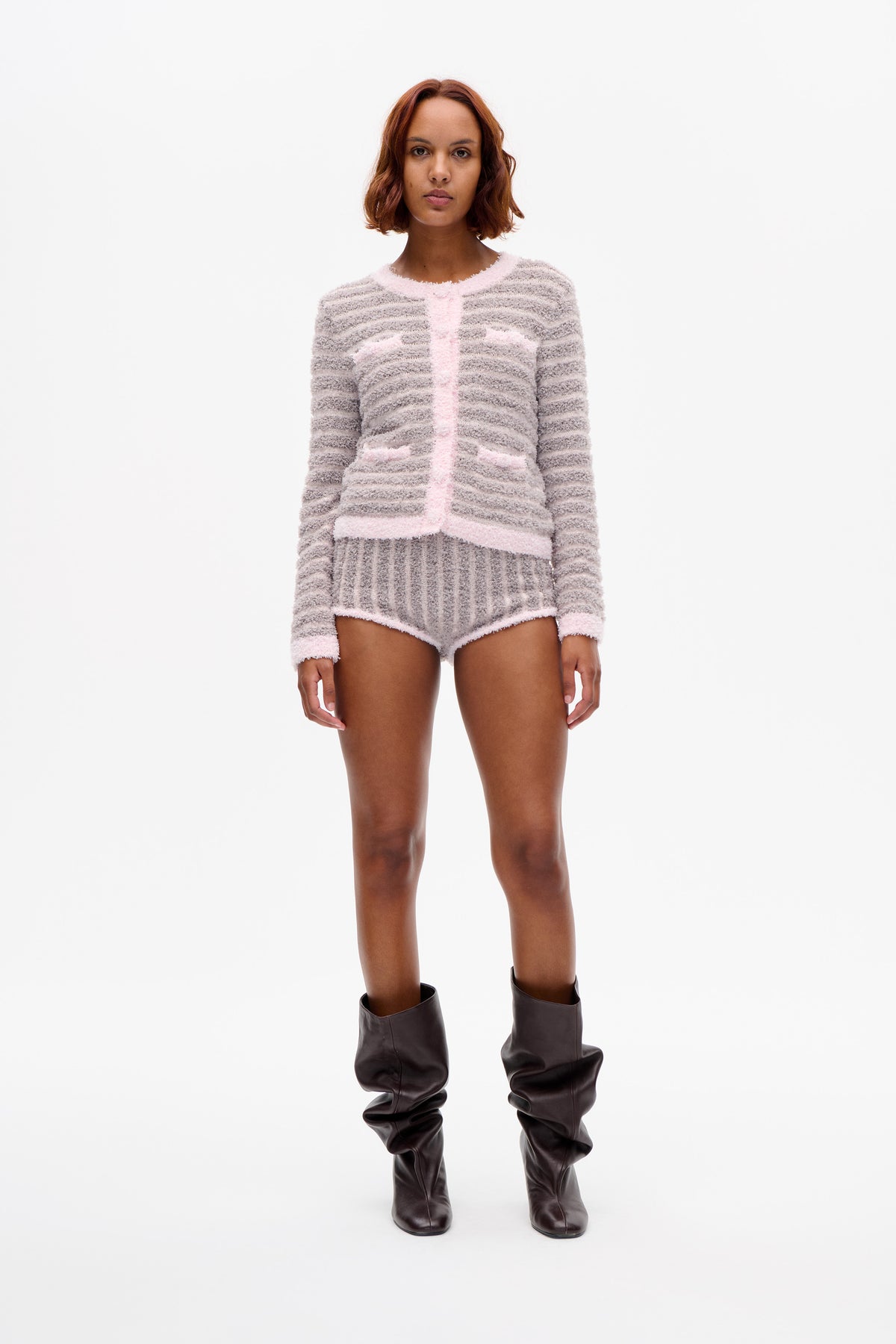Mannequin vu de face portant un pull en maille duveteuse à rayures gris et crème et un short assorti bordé de rose pâle.