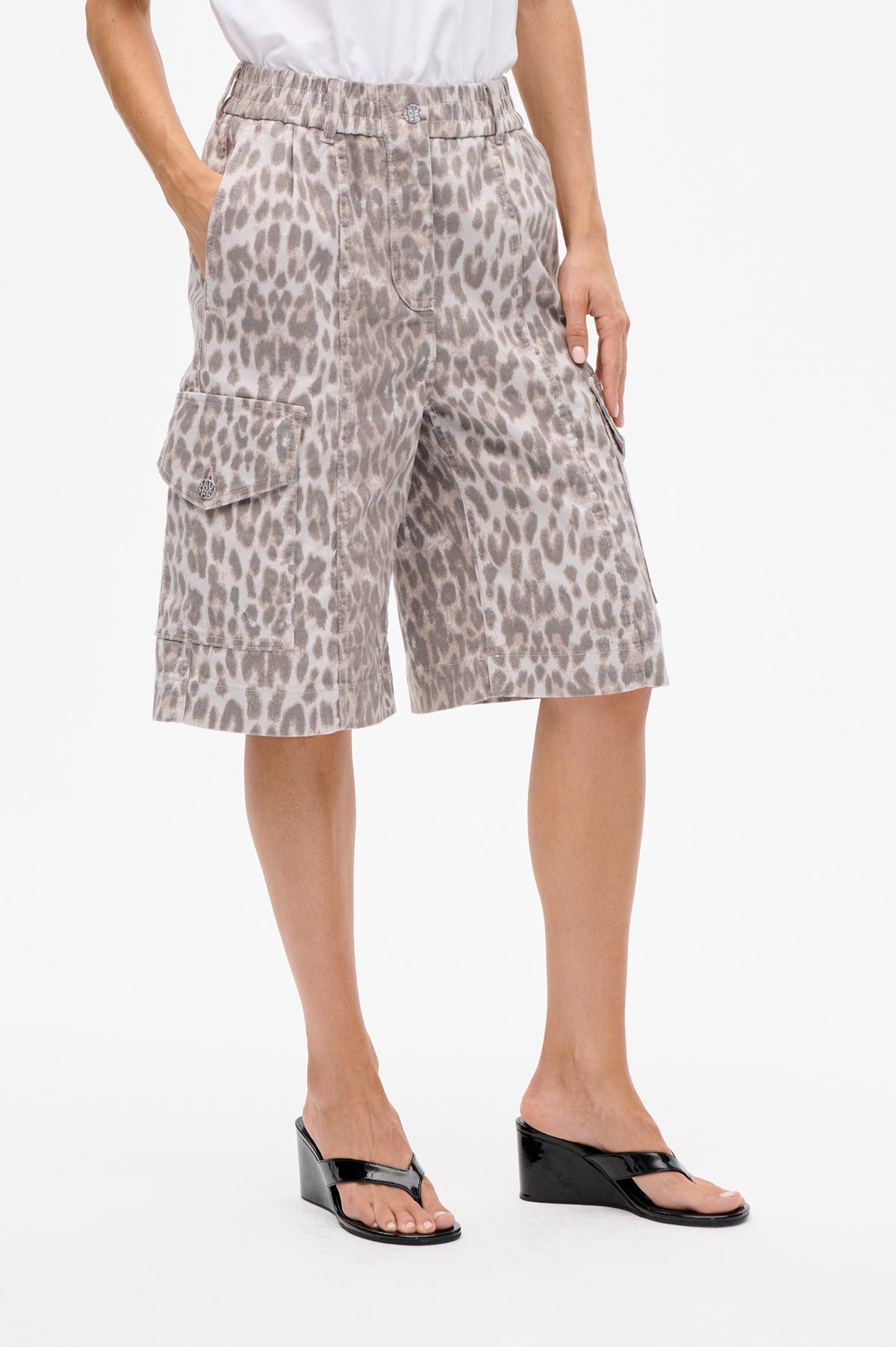 Detail van de voorkant van knielange cargoshorts met beige en grijze dierenprint, elastische tailleband en klepzakken