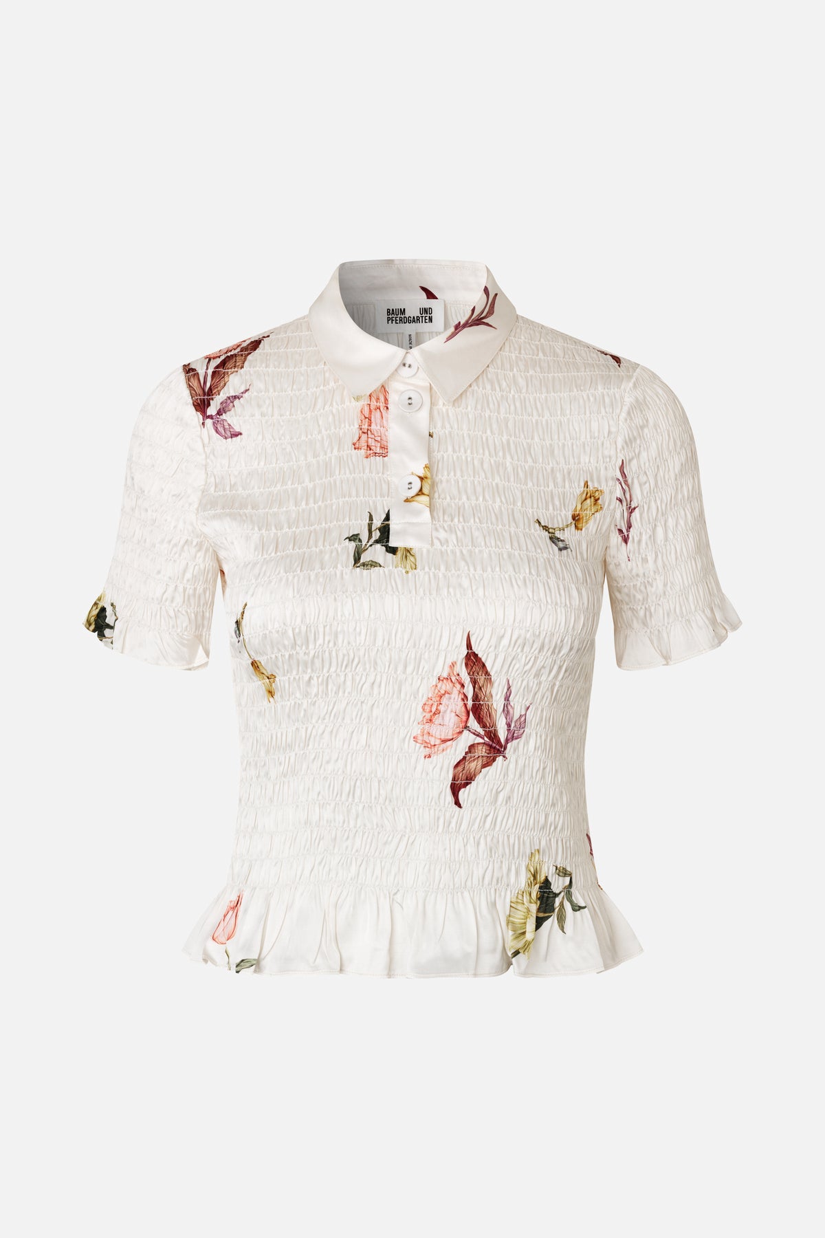 Front view of an ivory smocked blouse with a pointed collar, button placket, flutter sleeves, ruffled hem and scattered floral print.