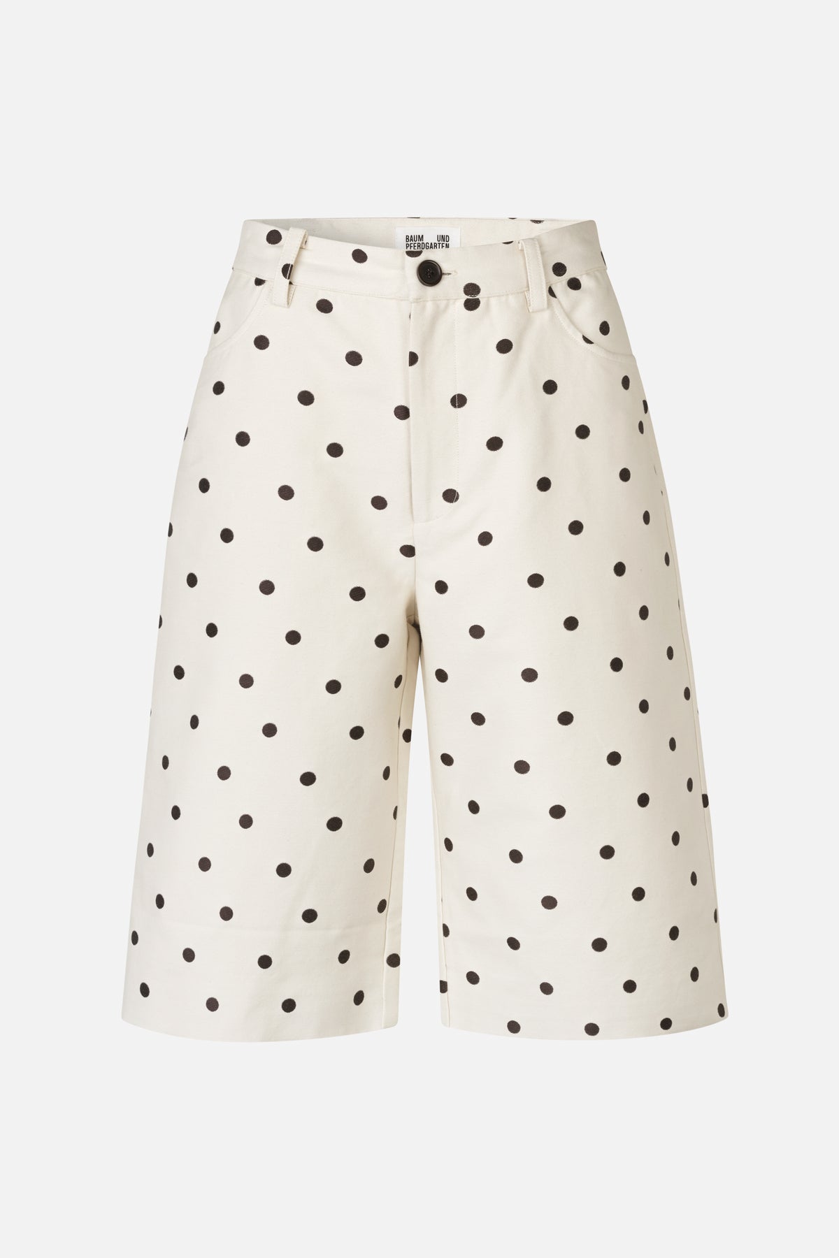 Vooraanzicht van ivoorkleurige, wijdvallende shorts met verspreide zwarte stippen, knoopsluiting, riemlussen en afgeronde voorzakken.