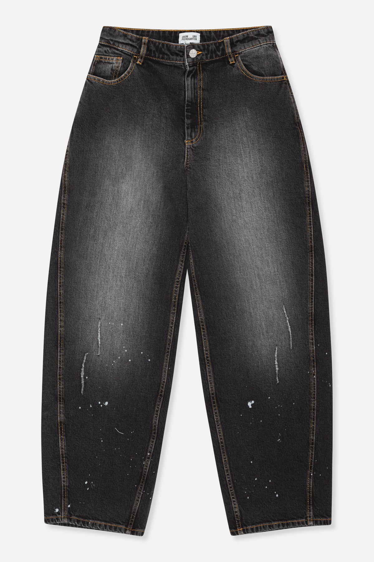 Vooraanzicht van houtskoolzwarte, wijd uitlopende jeans met oranje contraststiksels, vijfzakkenmodel en verspreide witte, verfachtige spatten.