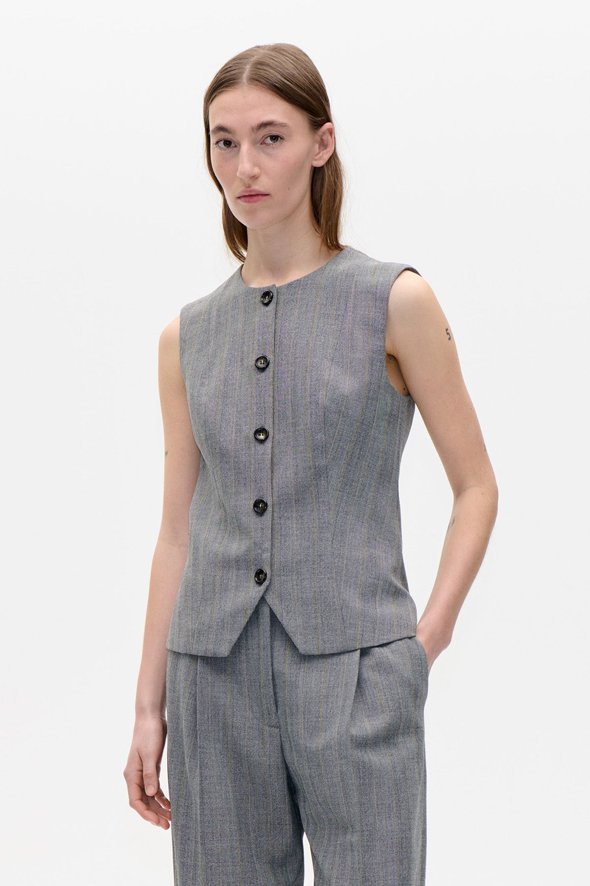 Front view of a grey sleeveless vest with black buttons and fine vertical stripes, paired with matching trousers.