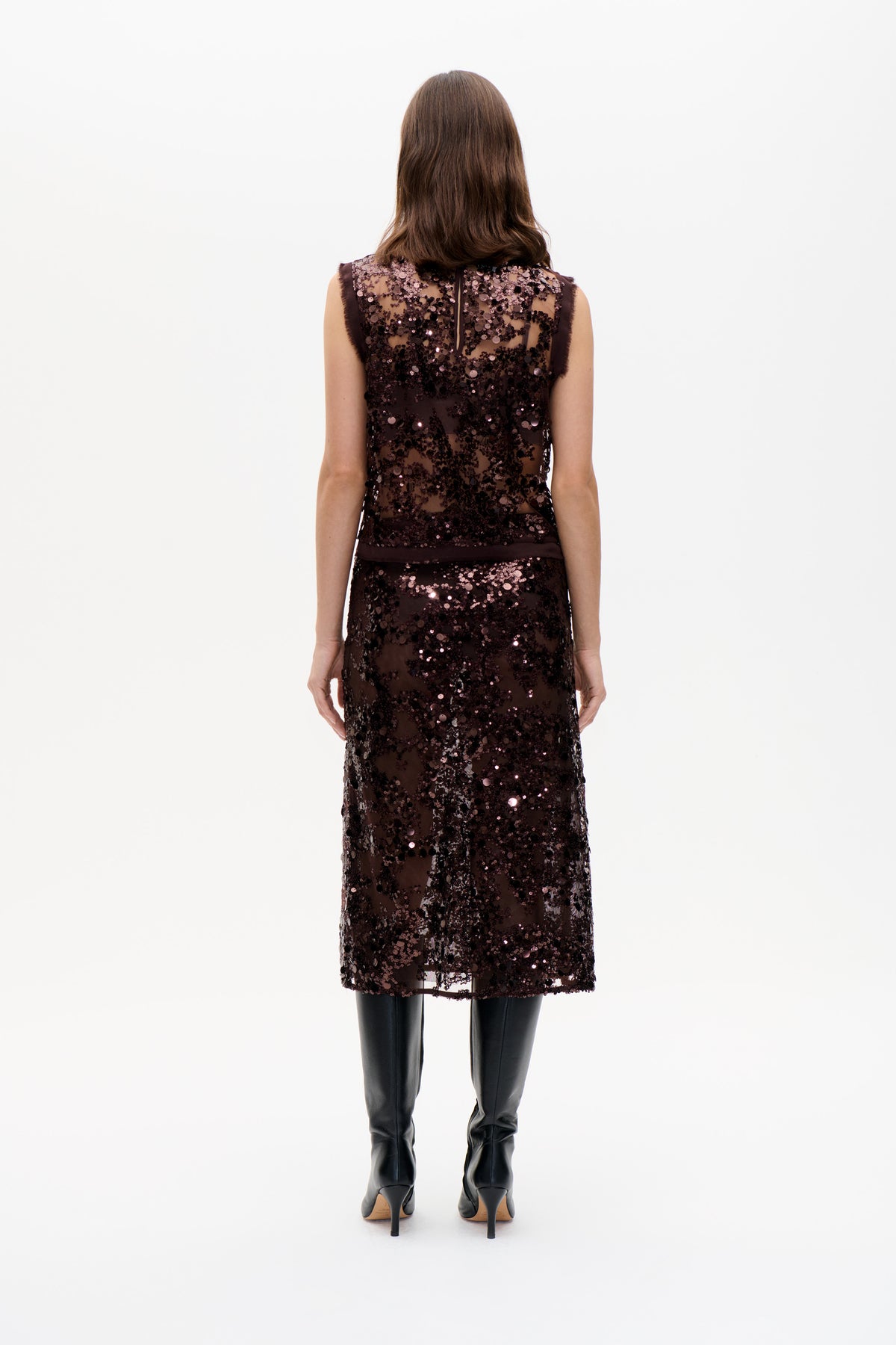 Back view of a sleeveless dark brown sheer dress covered in sequins, with a center-back zipper and knee-length hem.