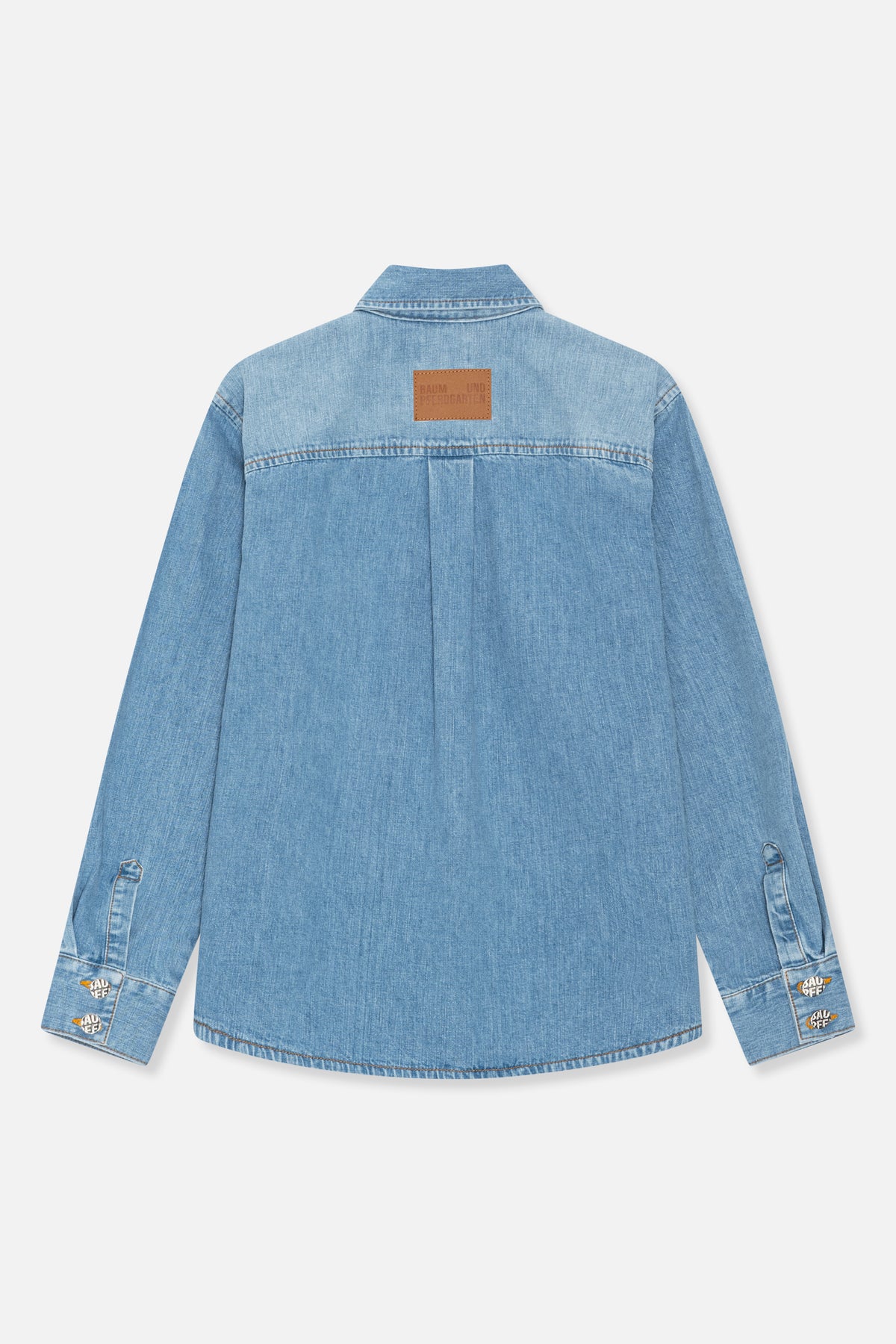 Back view of a light blue denim shirt jacket with a pointed collar, brown Baum und Pferdgarten patch and logo badges on the cuffs.