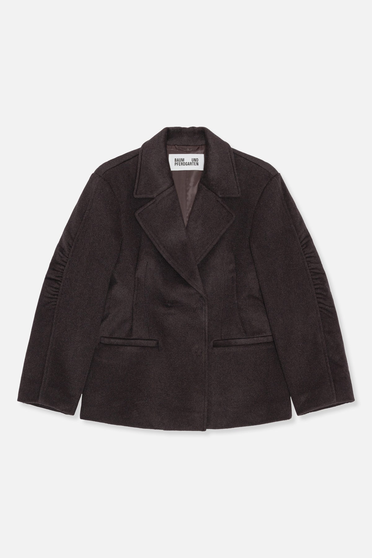 Front view of a dark brown coat with wide notched lapels, a concealed front closure, welt pockets and gathered sleeve details.