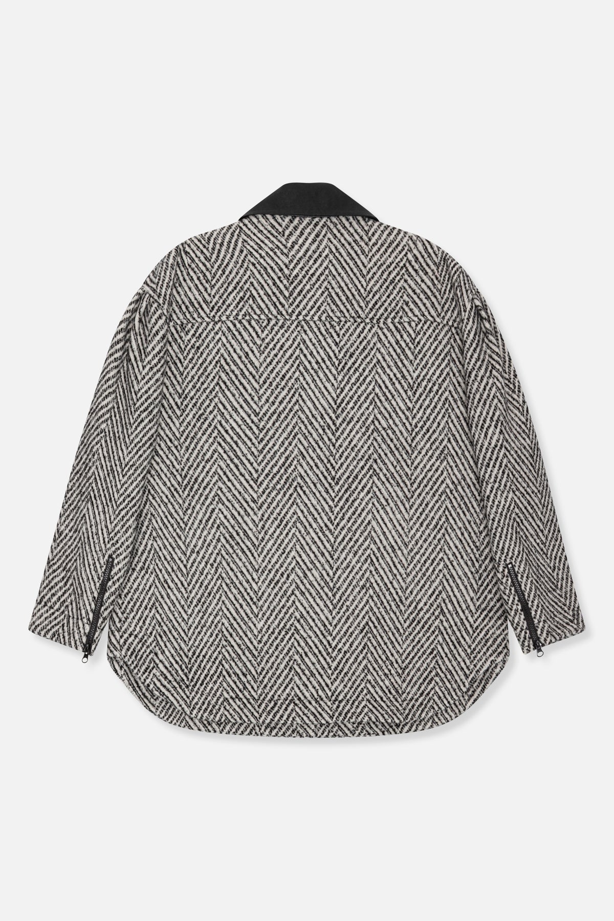 Back view of a black and ivory chevron-patterned jacket with a solid black collar and zippered side openings.