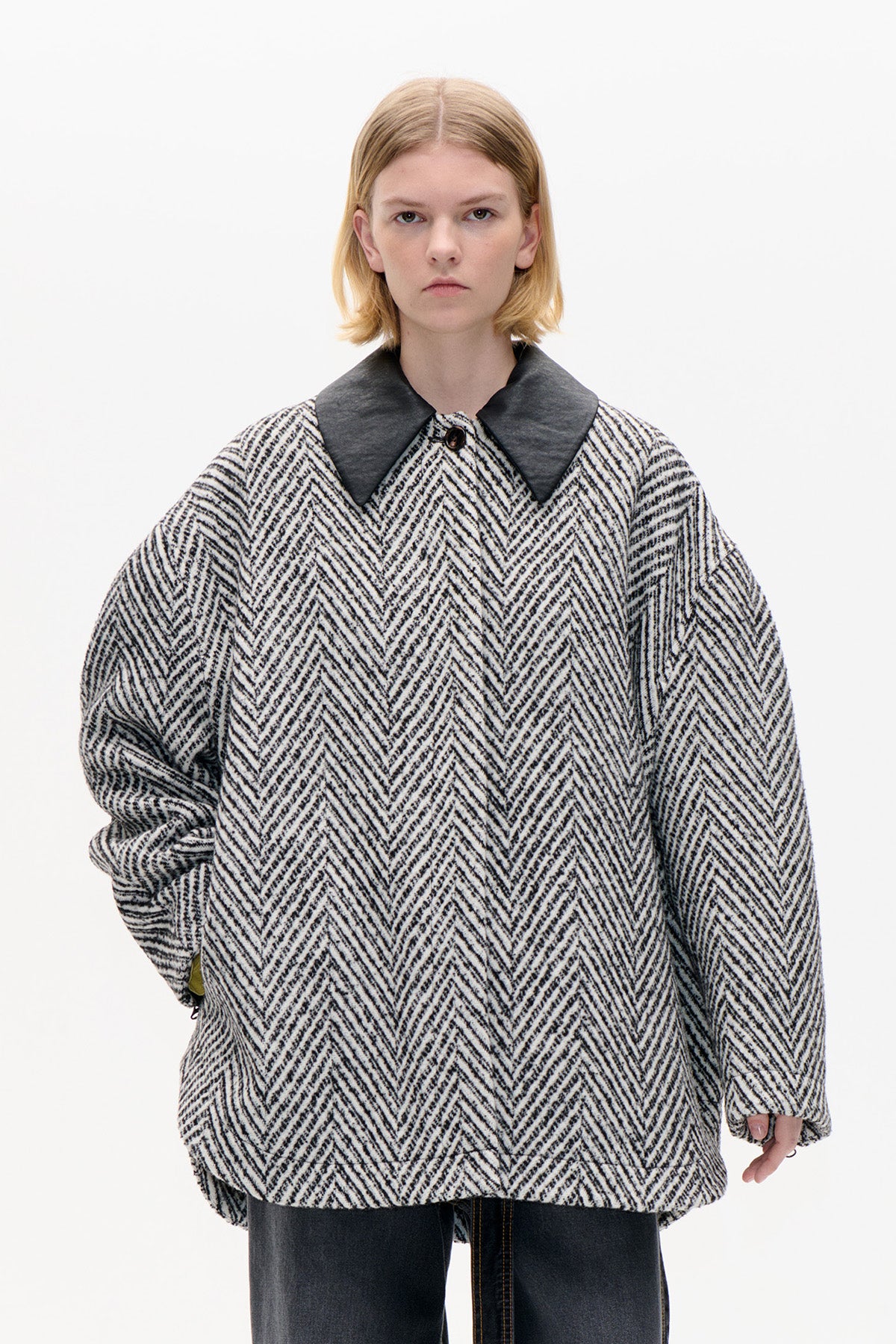 Front view of an oversized black-and-cream chevron-patterned coat with a wide charcoal collar and long sleeves