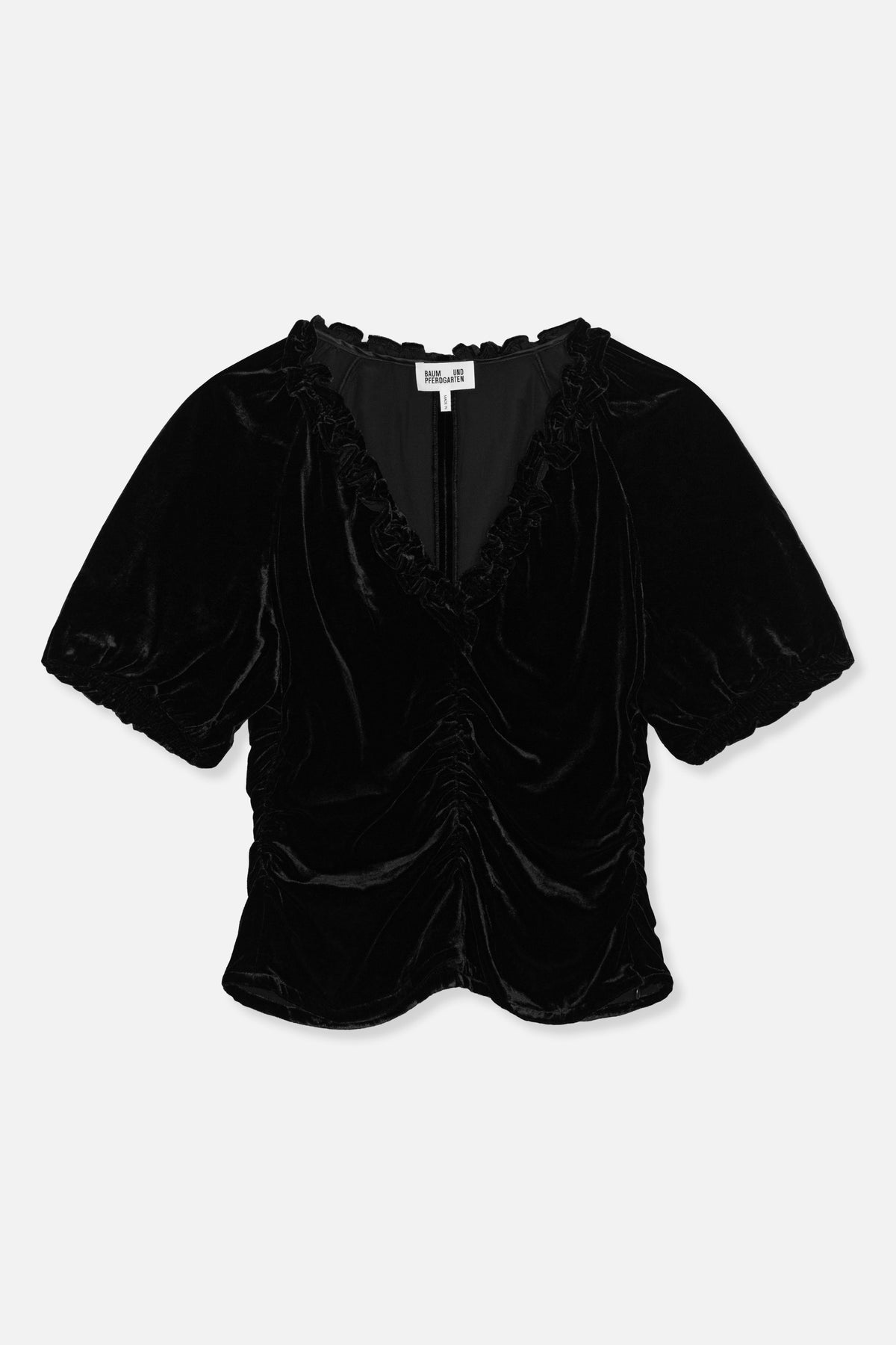 Front view of a black velvet blouse with puff sleeves, gathered cuffs, a ruffled V-neckline and ruched front.