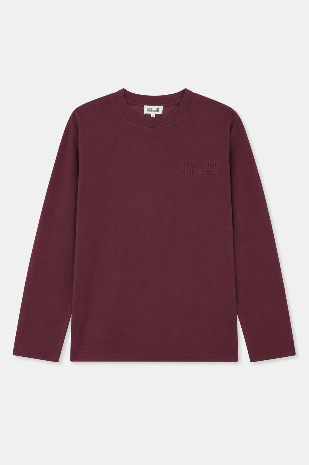 Vooraanzicht van een bordeauxkleurige blouse met lange mouwen en ronde hals, met subtiele ton-sur-ton Baum und Pferdgarten-letters op de borst.