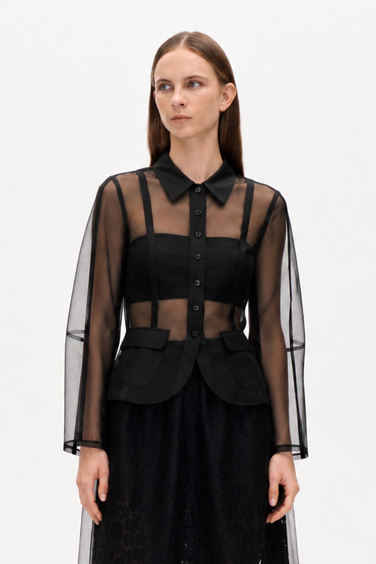Black sheer long-sleeved button-front blouse with pointed collar, opaque trim and flap pockets, shown from the front.