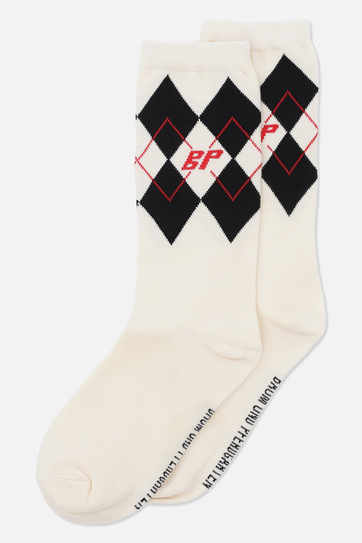 Pair of cream crew socks with black argyle diamonds, red outlined diamonds, and red lettering