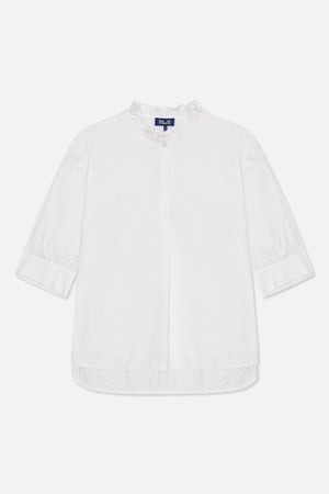 White blouse with a ruffled stand collar, front button placket, three-quarter sleeves with wide cuffs, and a curved hem