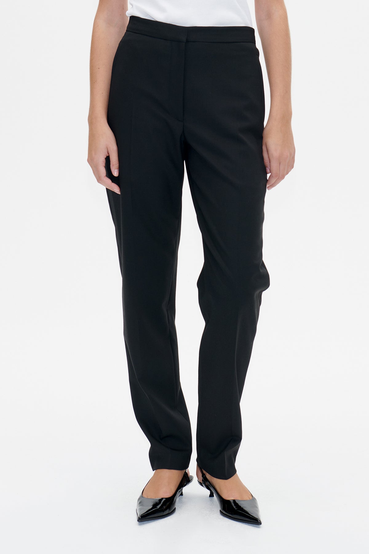 Front detail of black straight-leg trousers with a wide waistband, worn with a white top.