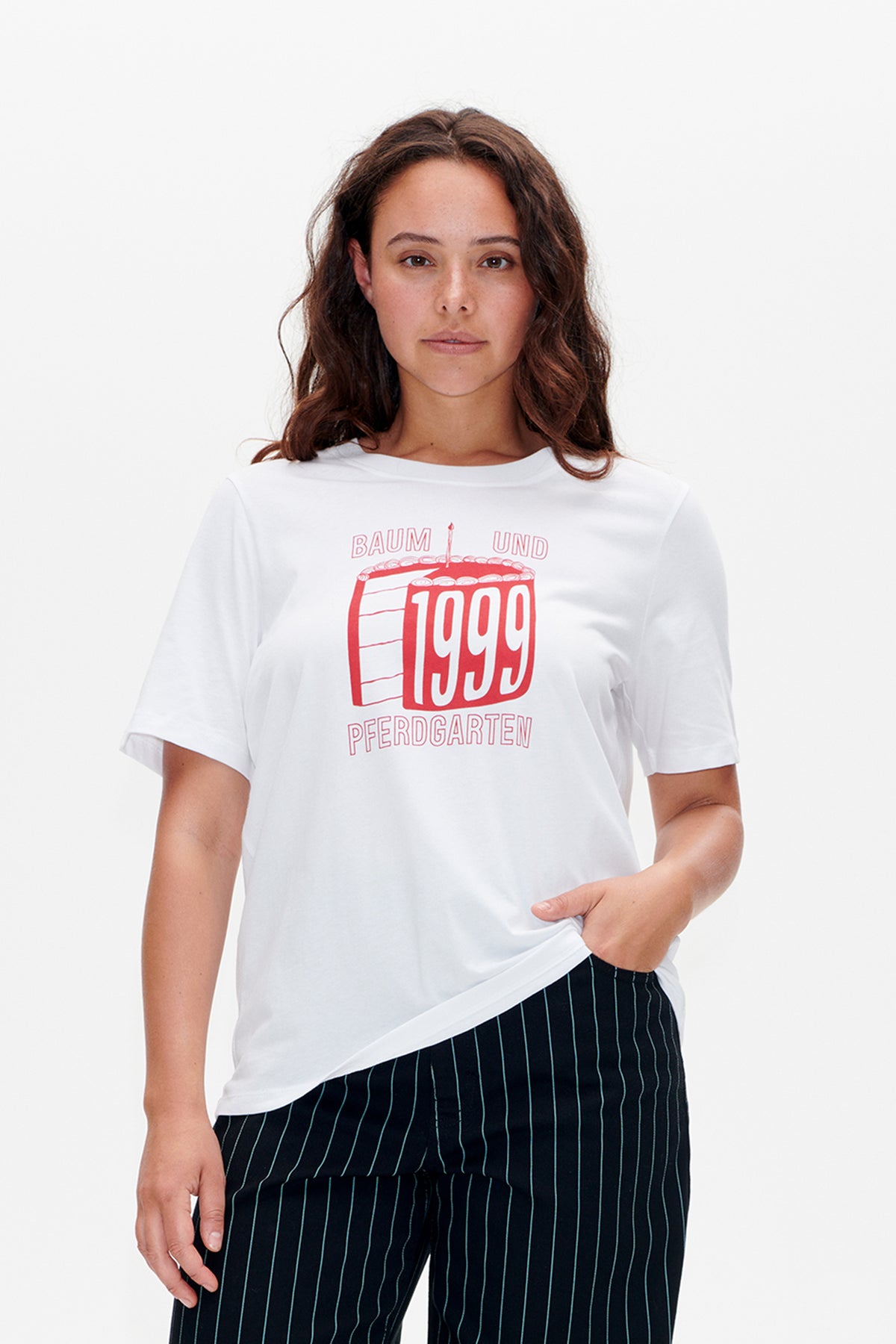 Vorderansicht eines weißen kurzärmeligen T-Shirts mit einer roten Baum und Pferdgarten-Grafik eines Geburtstagskuchens mit der Jahreszahl 1999.