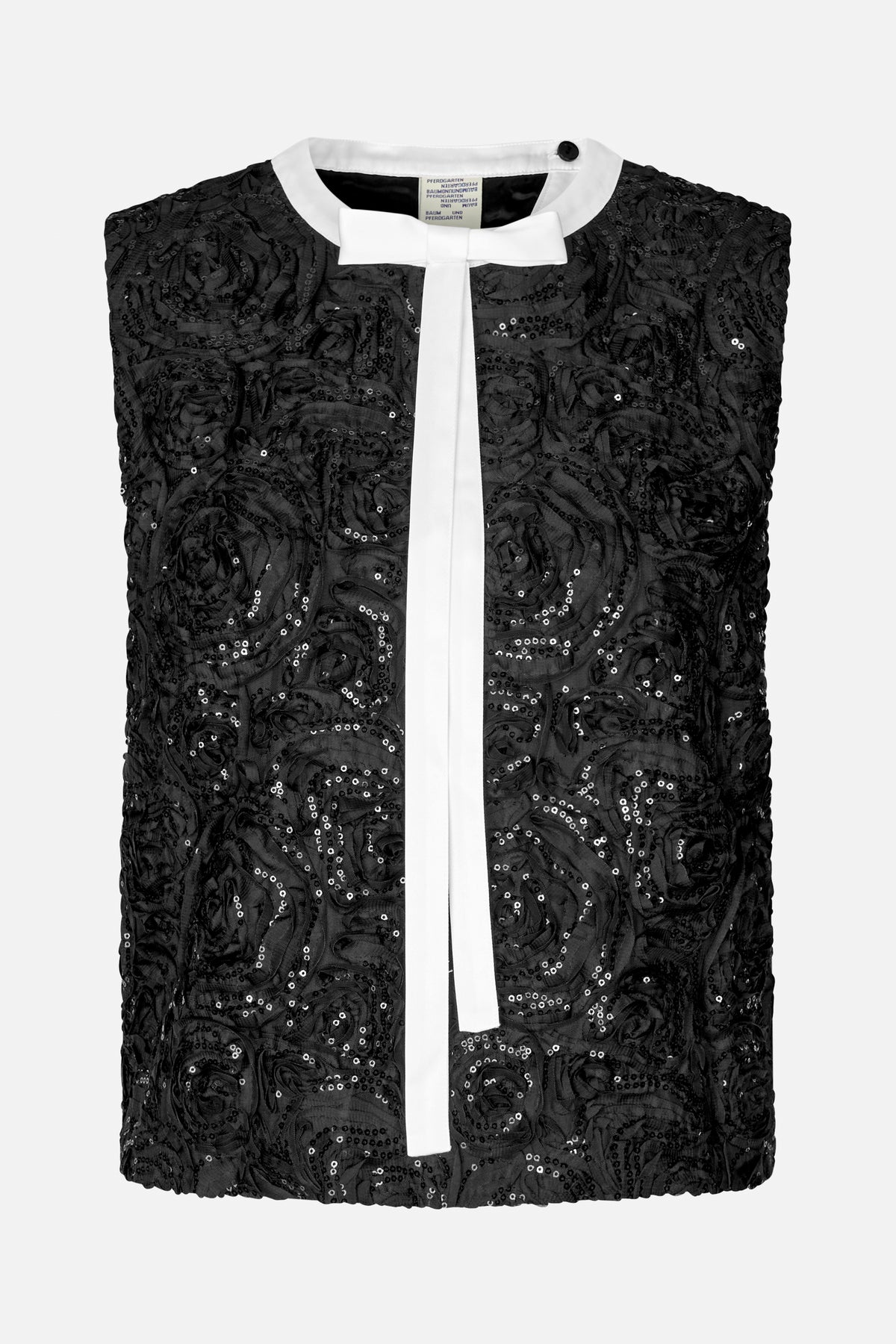 Front view of a black sleeveless top with raised floral detailing, scattered sequins, a white round collar and a long white bow tie.