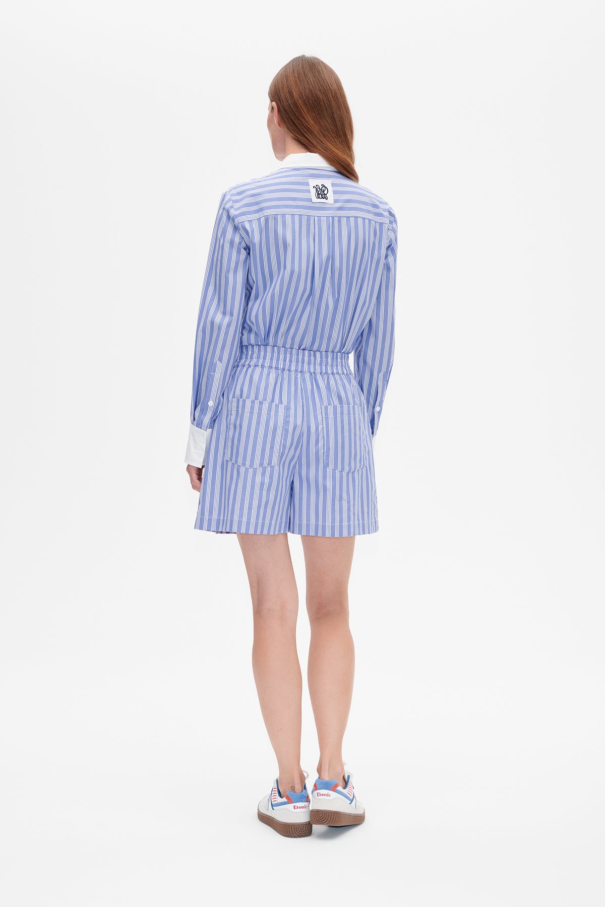 Back view of a blue-and-white striped long-sleeve shirt with a white collar and cuffs, paired with matching shorts.
