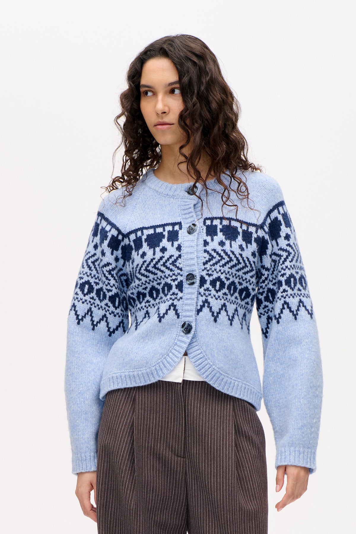 Front view of a pale blue button-front cardigan with navy geometric knit patterning, ribbed trim and long sleeves.