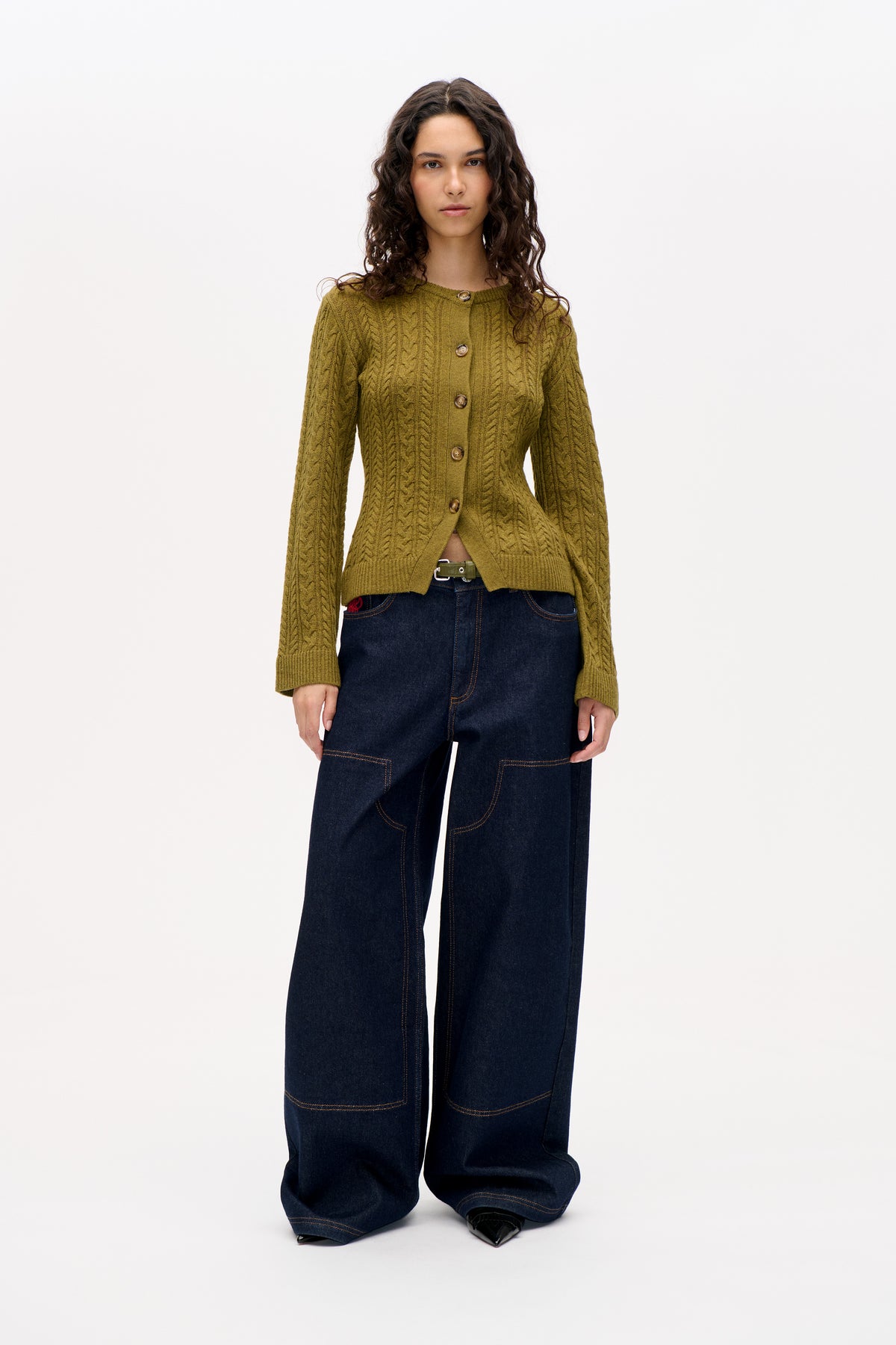 Vue de face d'un mannequin portant un cardigan torsadé vert olive boutonné et un jean large foncé.