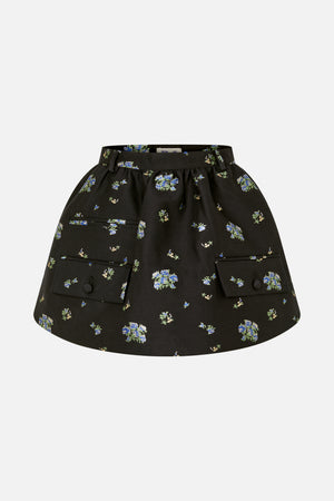 Vooraanzicht van een zwarte rok met verspreide bloemenprint in blauw en groen, riemlussen en twee grote klepzakken met knopen.