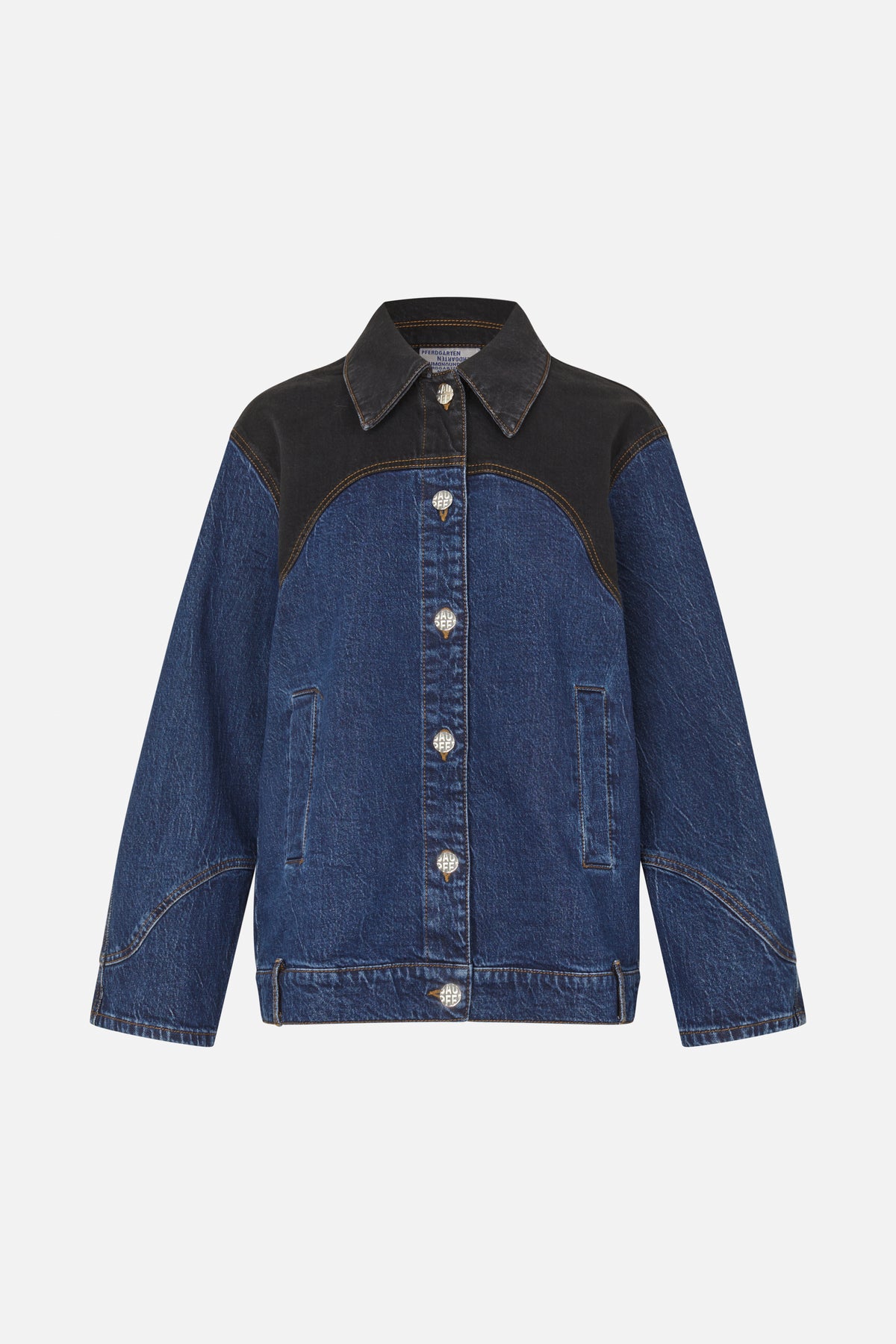 Front view of a blue denim jacket with black contrasting shoulder and chest panels, tan stitching, pointed collar and silver buttons.