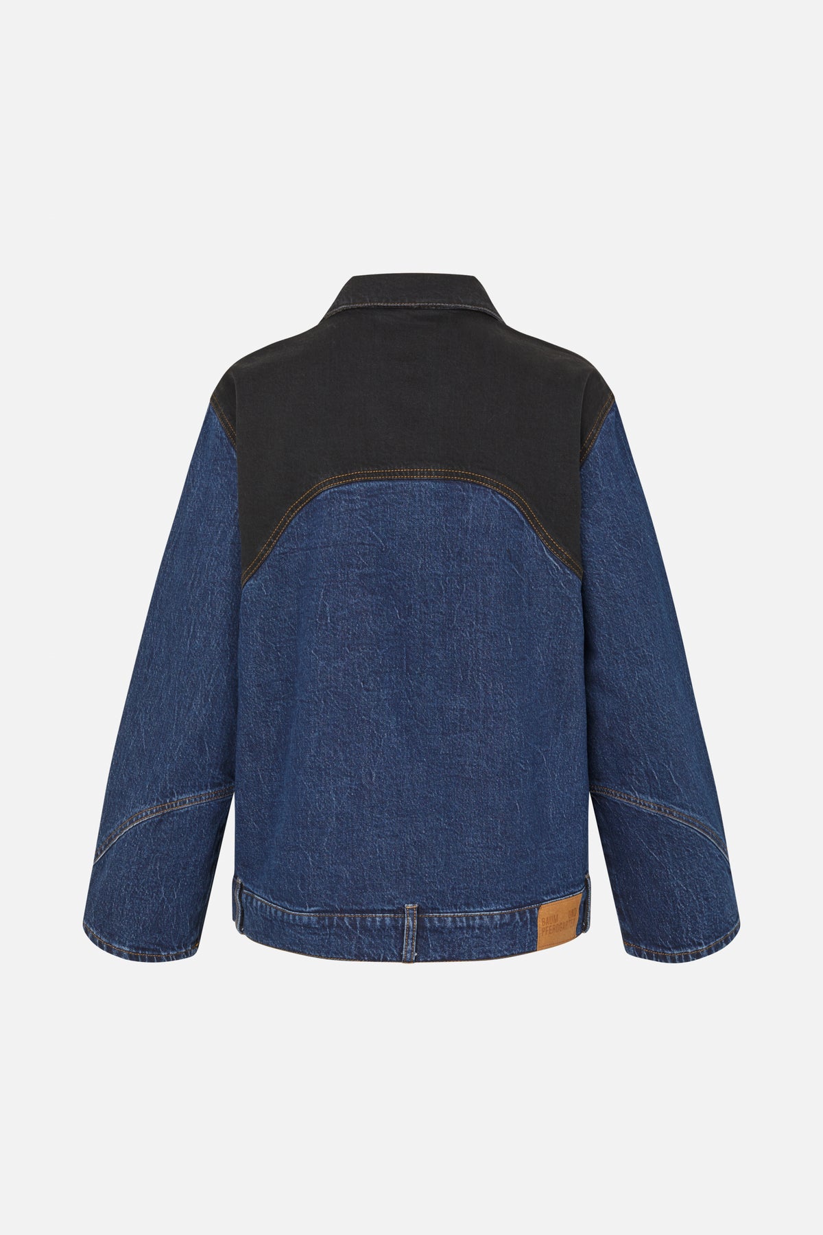 Back view of a blue denim jacket with a contrasting charcoal-black upper panel and curved contrast stitching.