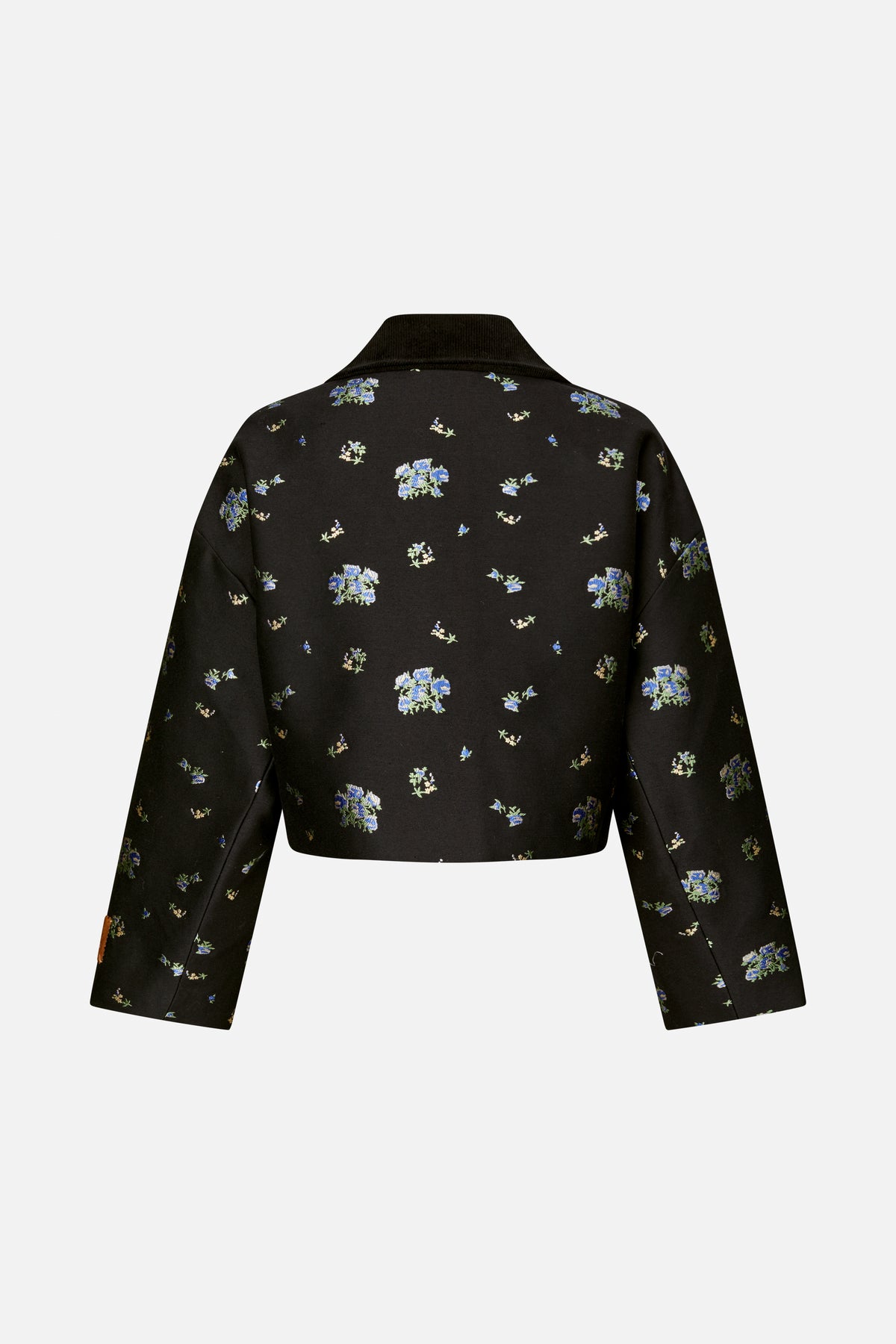 Back view of a black long-sleeved jacket with a broad collar and scattered blue, green and cream floral pattern.