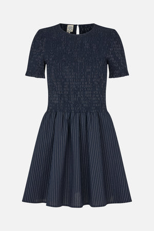 Front view of a navy short-sleeved dress with a smocked bodice and gathered skirt patterned with fine white vertical stripes.