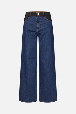 Vorderansicht einer dunkelblauen, weit geschnittenen Jeans mit schwarzem denim-Kontrast am Bund und an den Taschen, goldenen Nähten und einem Knopfverschluss.