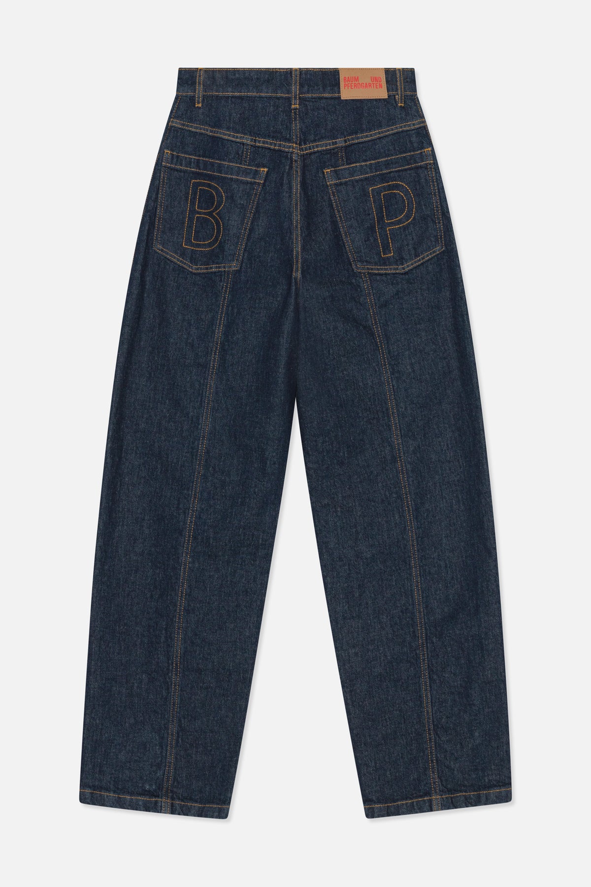 Back view of dark indigo wide-leg jeans with contrast stitching, two back pockets embroidered with outlined letters and a tan waistband patch.