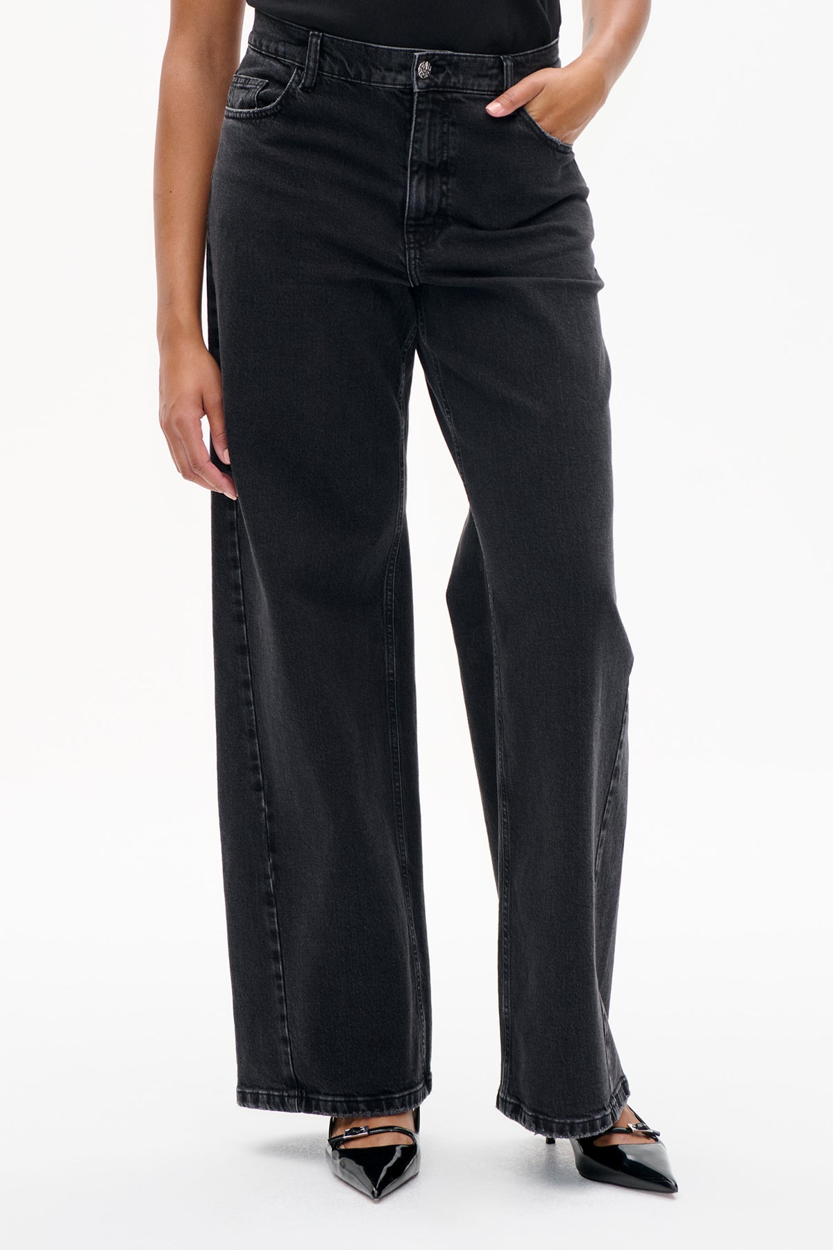 Front detail of charcoal-black wide-leg jeans with a button fly, belt loops and front pockets.