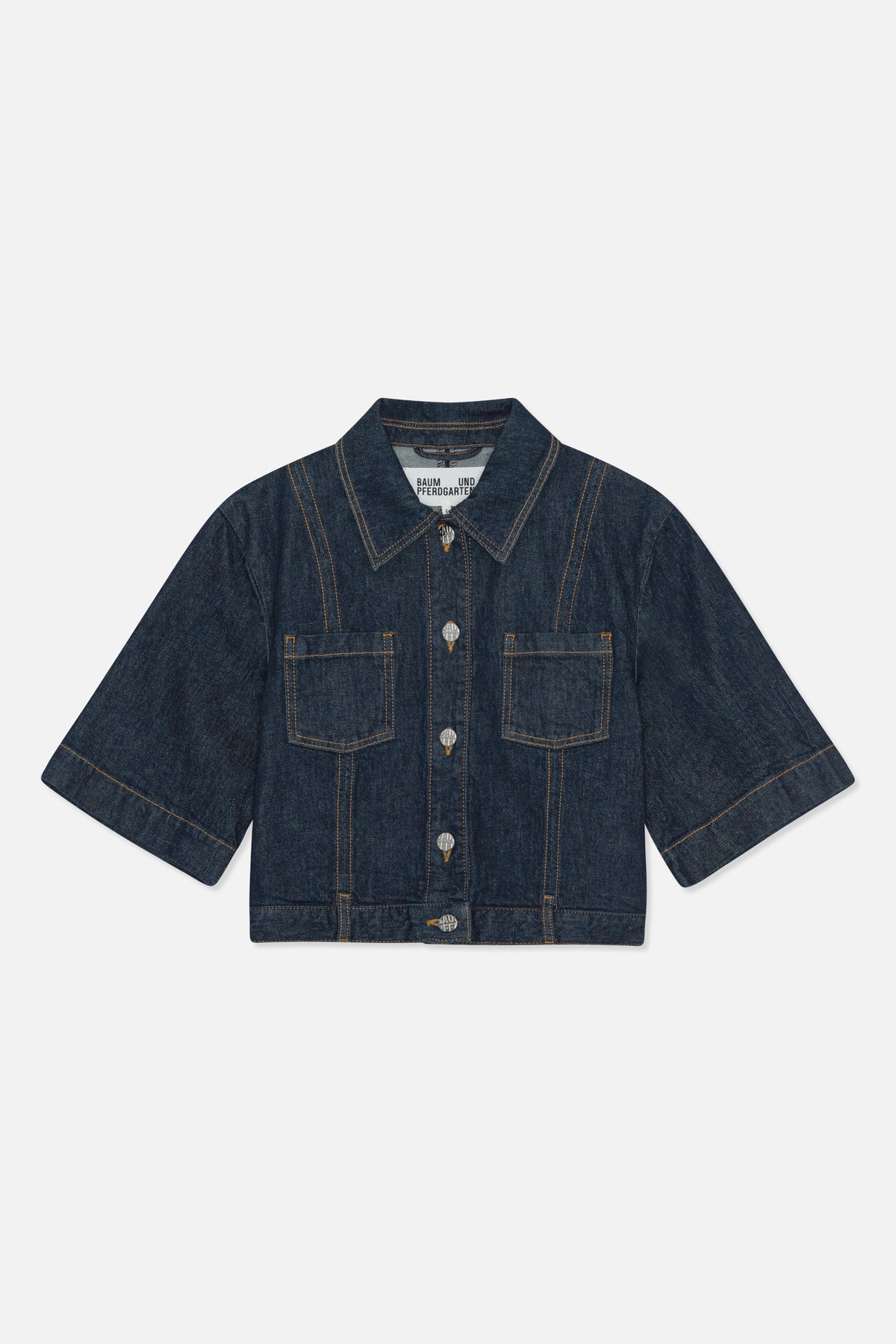 Vue de face d'une veste en denim indigo foncé à manches courtes et larges, surpiqûres contrastantes, col pointu, boutons argentés et deux poches plaquées.