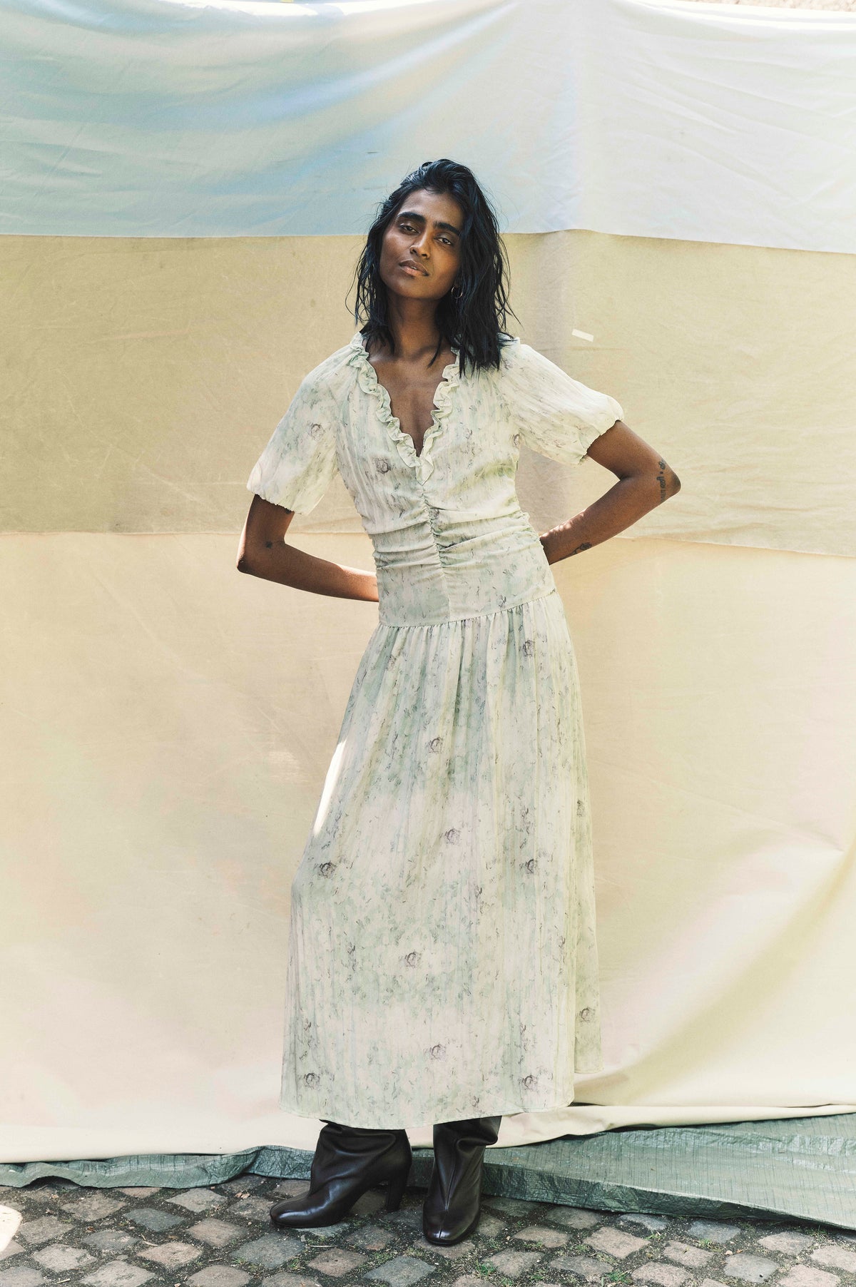 Campaign portrait of a model in a pale mint floral-print maxi dress with puff sleeves, a ruffled V-neck and gathered waist